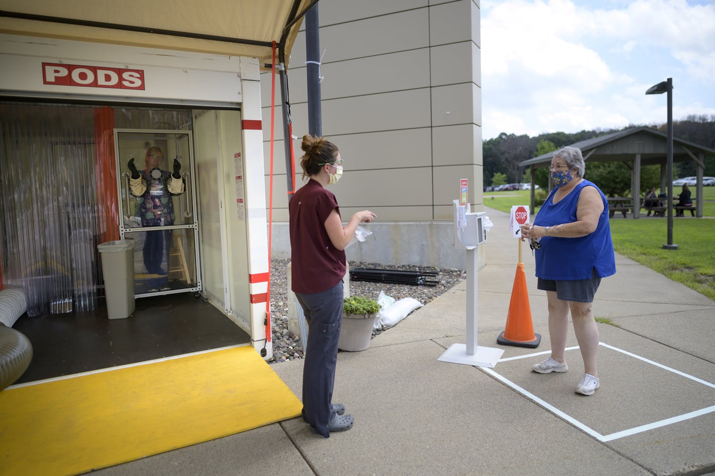 Camille Koivisto, of Stacy, Minn., waited to be tested for COVID-19 as her information was processed by medical assistant Alli Weihmann. ] aaron.lavinsky@startribune.com Walk-up testing was offered at M Health Fairview's Wyoming Clinic on Thursday, Aug. 13, 2020 in Wyoming, Minn. A medical worker administered nasal swab tests in a glass booth designed by the University of Minnesota College of Science and Engineering. It's use is meant to offer more protection to the tester and patient as well as