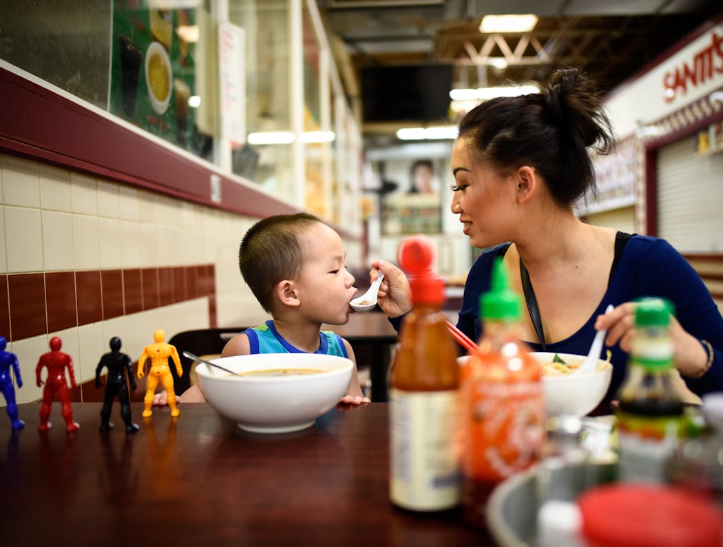 Pang Vang fed a meatball from her pho to her 3-year-old son Jysin at Hmong Village.