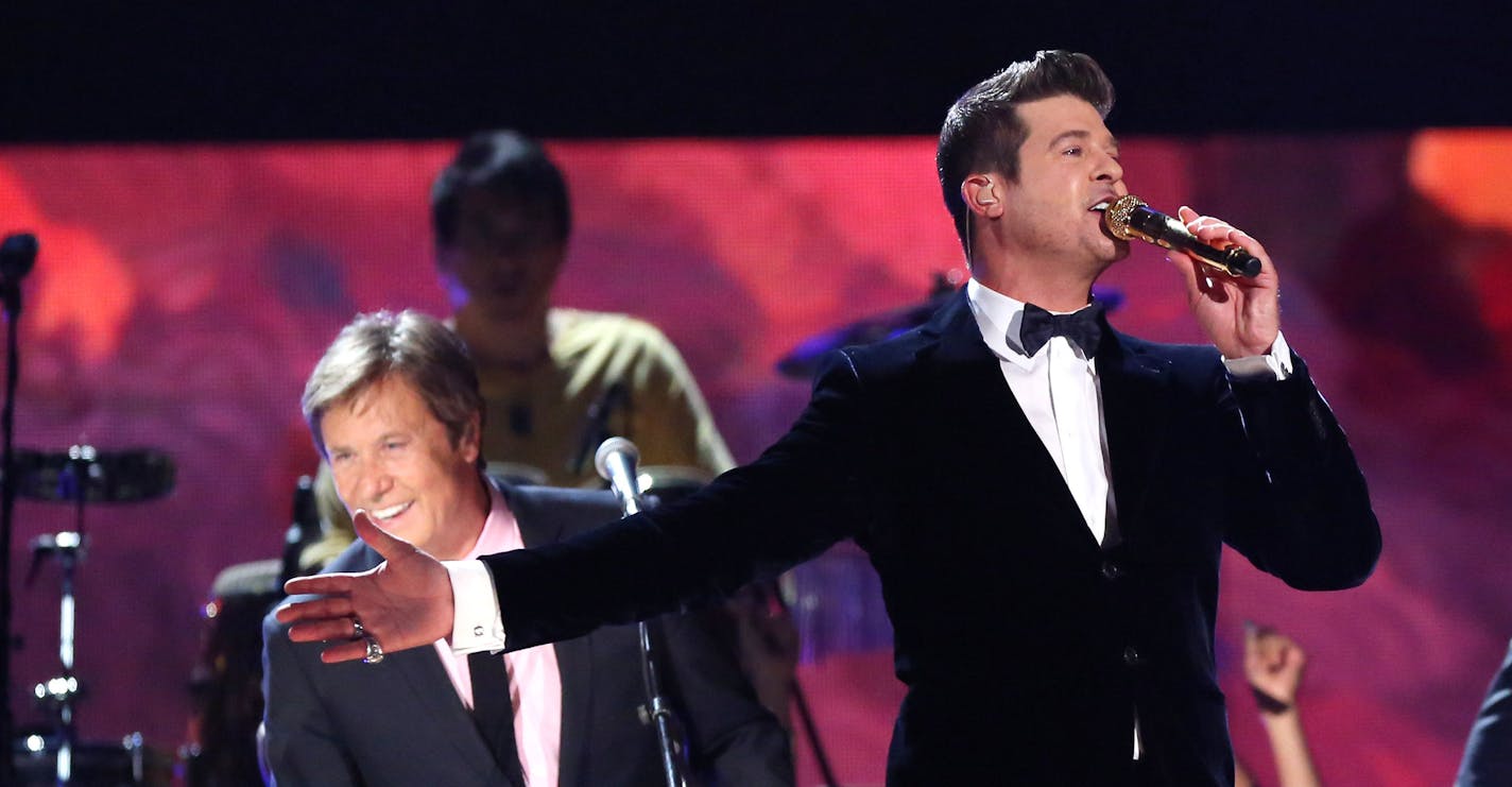 CORRECTS IDS OF CHICAGO MEMBERS - Robin Thicke, center, performs a medley with Robert Lamm, left, and Jason Scheff, of Chicago at the 56th annual Grammy Awards at Staples Center on Sunday, Jan. 26, 2014, in Los Angeles. (Photo by Matt Sayles/Invision/AP)