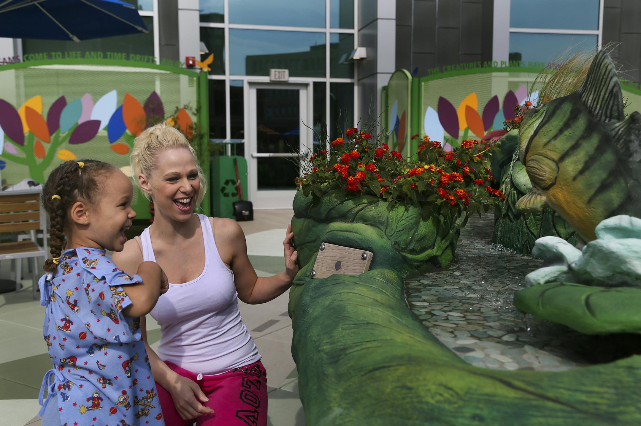 While on the new rooftop garden at Children's Hospital St. Paul, Alyssa Mgeni, 3, left, and her mom Aubrey Rahn, of St. Paul, tested out a new interactive fish fountain Thursday, June 20, 2013, in St. Paul, MN. ](DAVID JOLES/STARTRIBUNE) djoles@startribune.com Children's Hospital St. Paul is now home to a new rooftop garden designed to help kids heal.**Alyssa Mgeni, Aubrey Rahn,cq