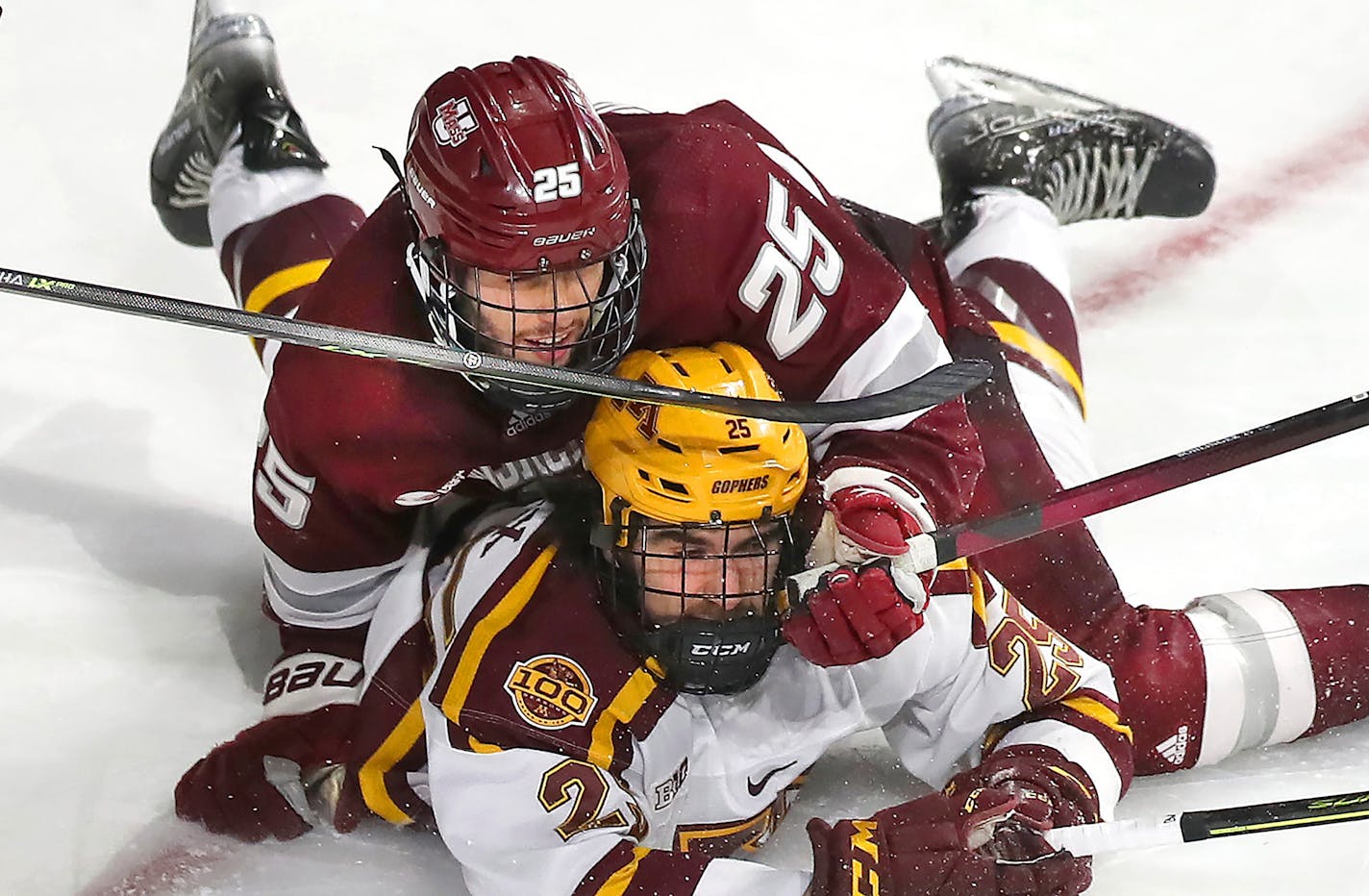 Massachusetts defenseman Aaron Bohlinger (25) collides with Minnesota's Jack Perbix, bottom, in the second period of an NCAA college hockey game in Worcester, Mass., Friday, March 25, 2022. (