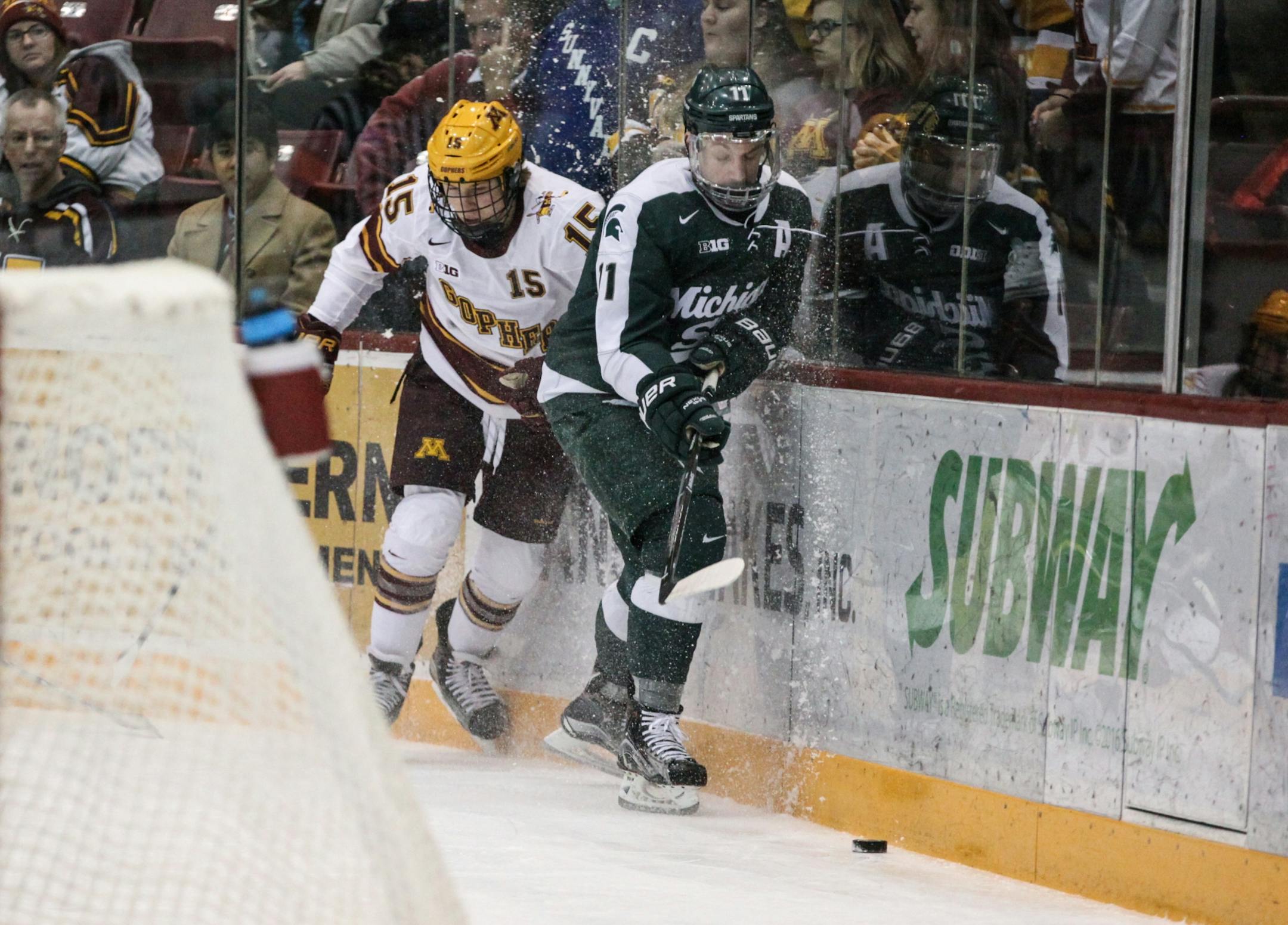 Minnesota Gophers� Rem Pitlick (15) and Michigan State Spartans� Rhett Holland (11) chase the puck in the first period.