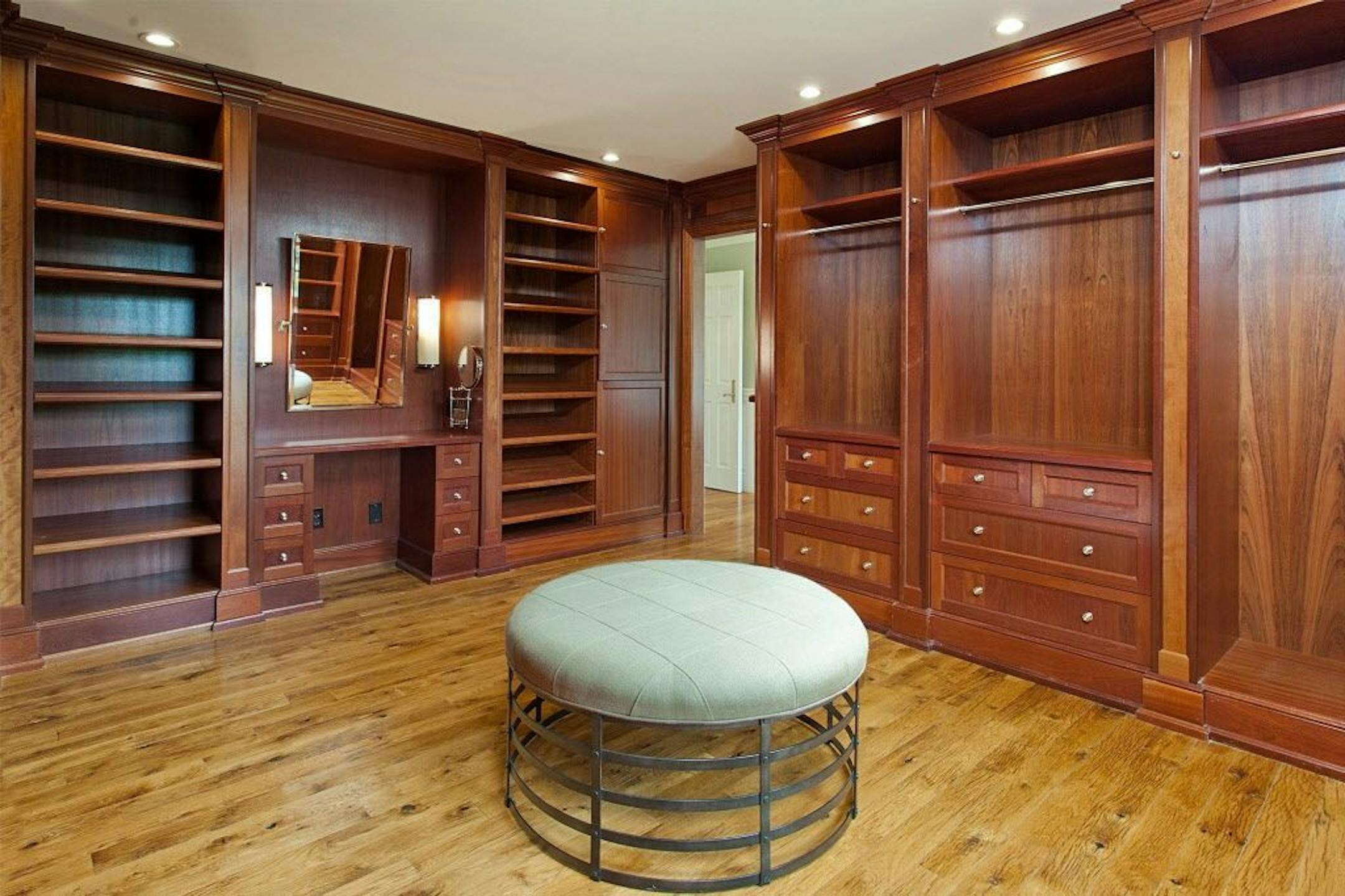 Big walk-in closet with cherry built-in drawers and vanity.