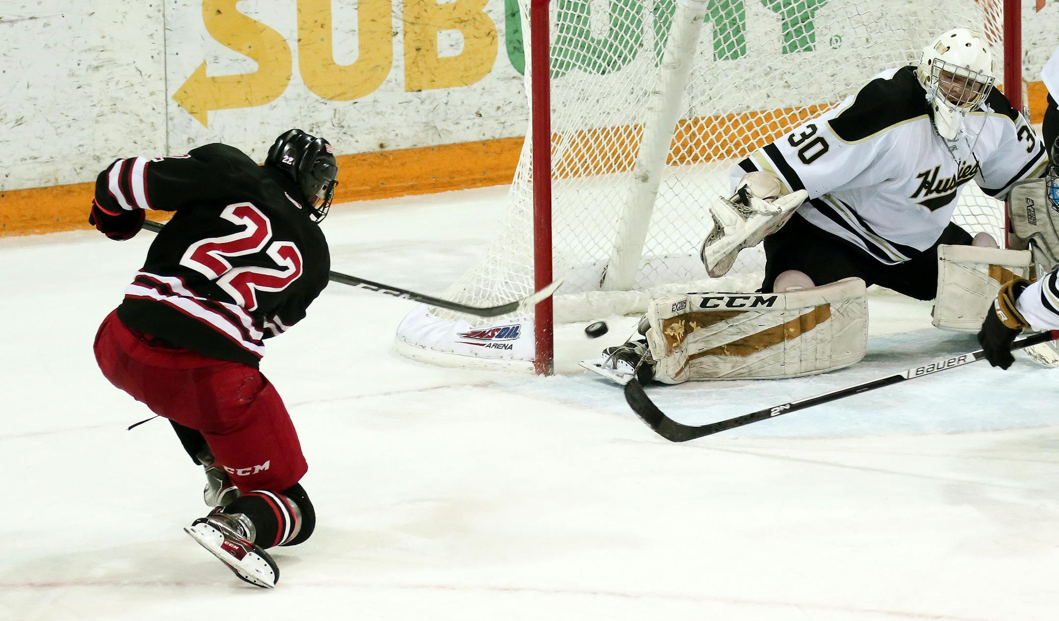Duluth East's Ryder Donovan buries the game winning goal, 36 seconds into overtime, past Andover goaltender ben Fritsinger, to win the Section 7AA championship 4-3 Thursday night at Amsoi Arena. Photo: Dave Harwig, SportsEngine