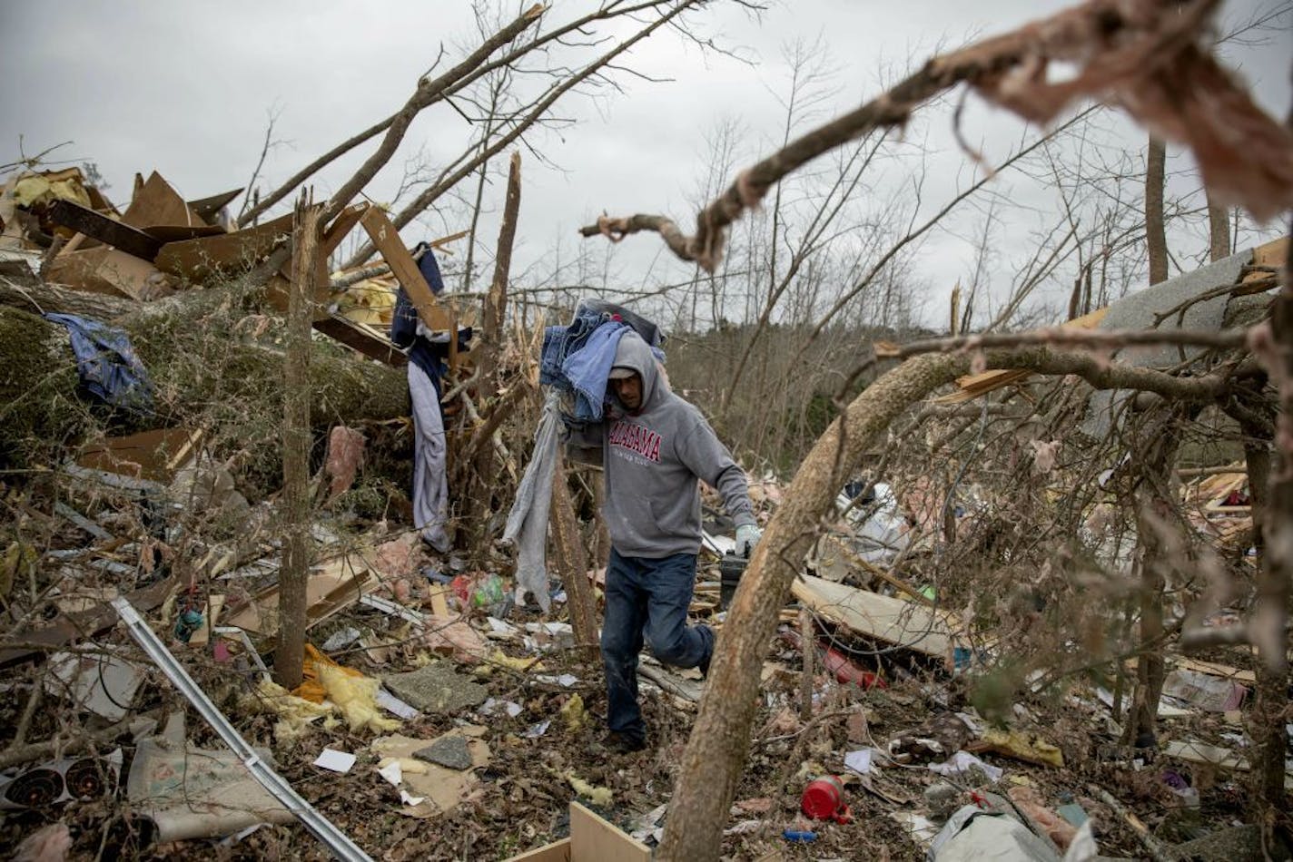 Danny Allen helps recover belongings while sifting through the debris of a friend's home destroyed by a tornado in Beauregard, Ala., Monday, March 4, 2019.