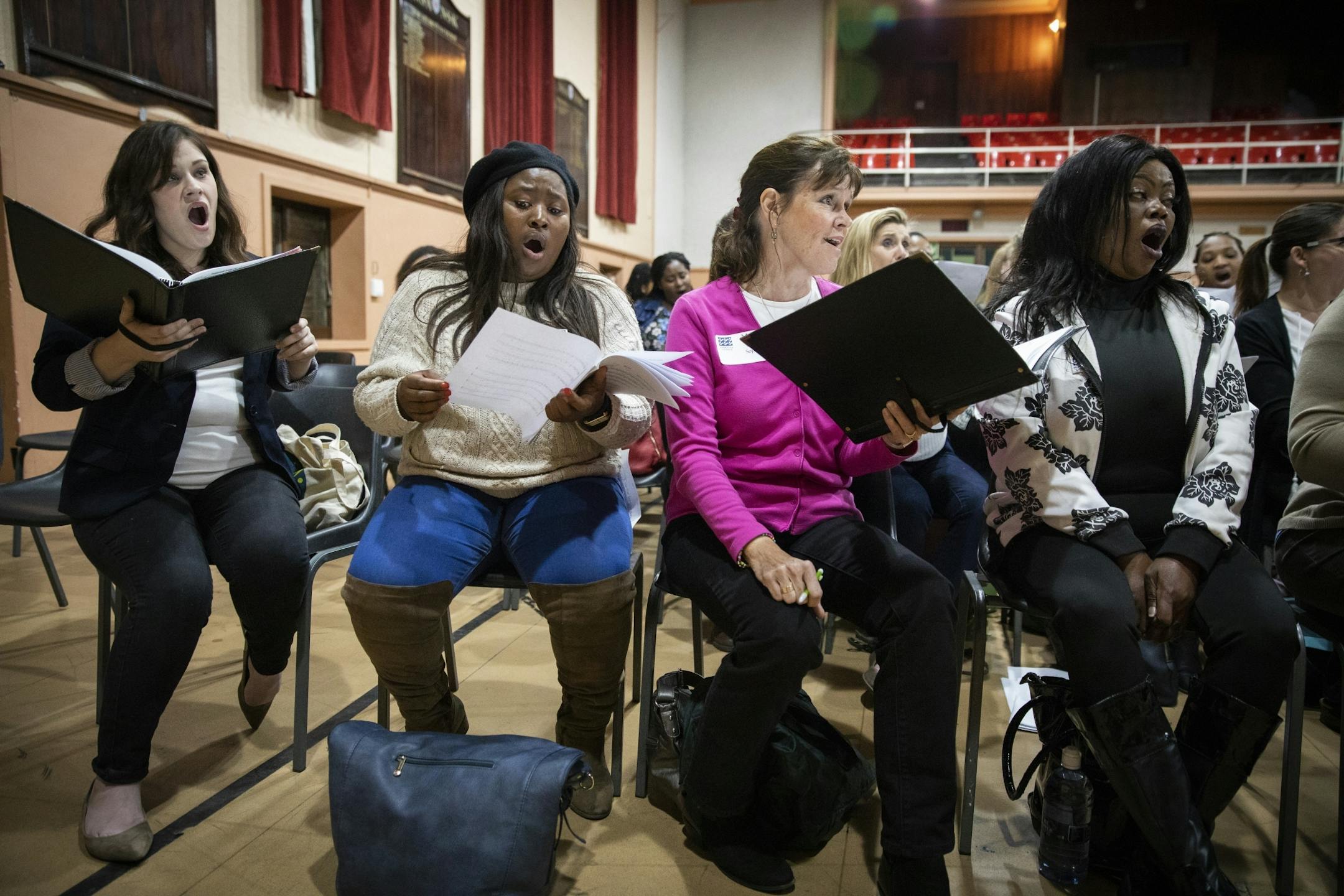 Singers in the soprano section rehearse.