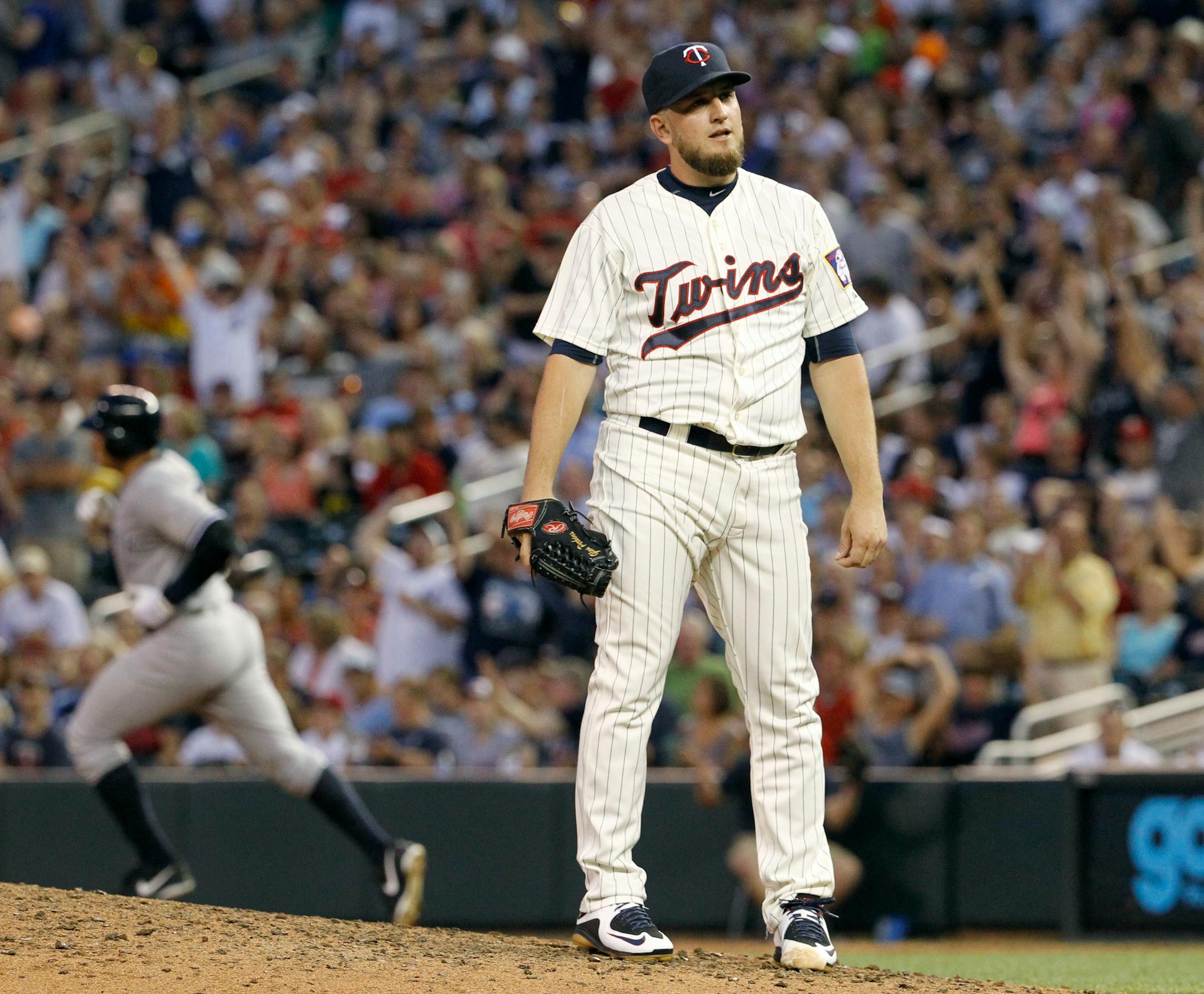 Minnesota Twins relief pitcher Glen Perkins looks away as New York Yankees' John Ryan Murphy rounds first base on his three-run home run during the ninth inning of a baseball game in Minneapolis, Saturday, July 25, 2015. The Yankees won 8-5. (AP Photo/Ann Heisenfelt)