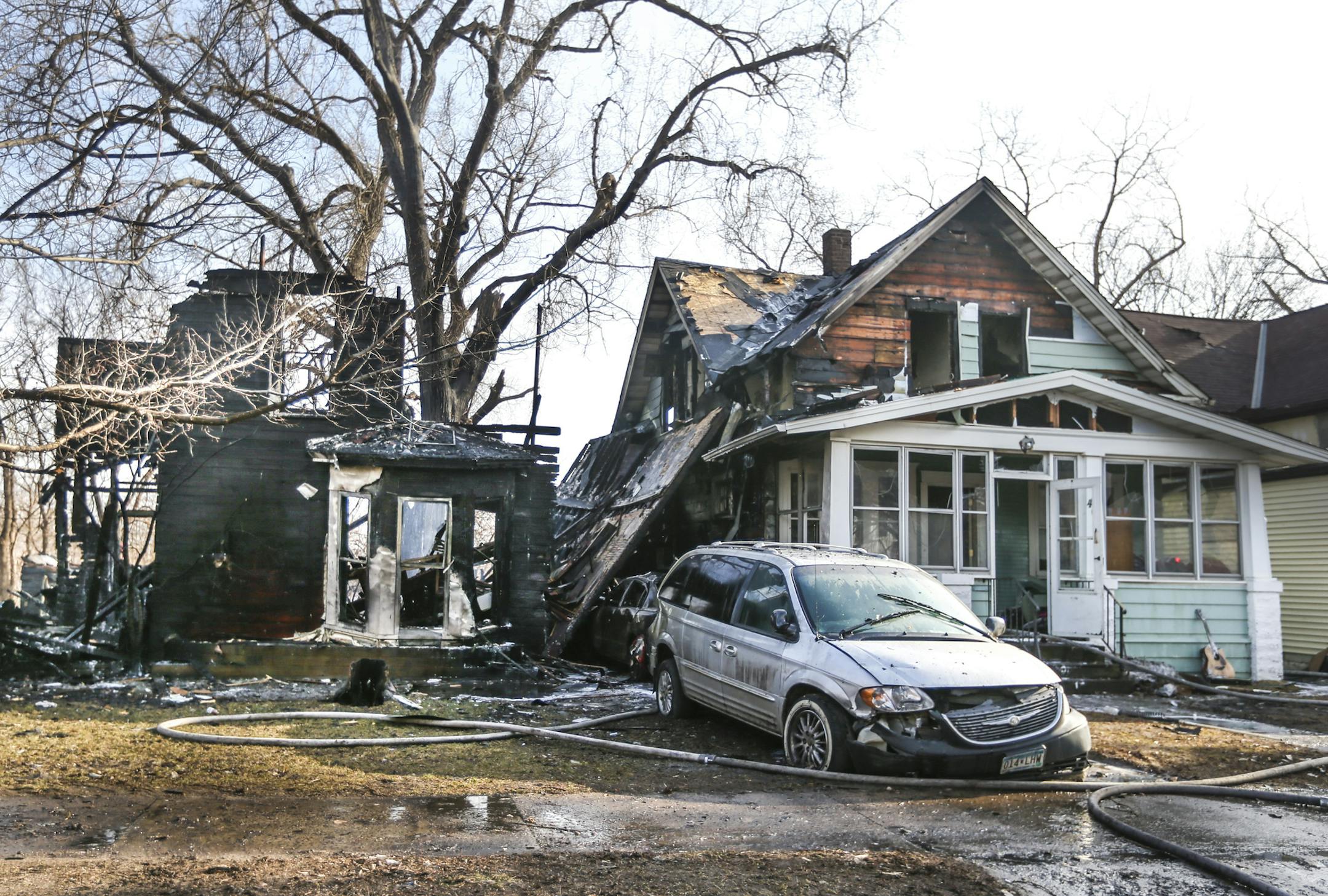 Fire fighters worked at the scene of a fire that destroyed two homes when a branch broke off the tree pictured and hit a electrical wire on Front Street in St. Paul, Minn., on Wednesday, April 1, 2015. ] RENEE JONES SCHNEIDER • reneejones@startribune.com
