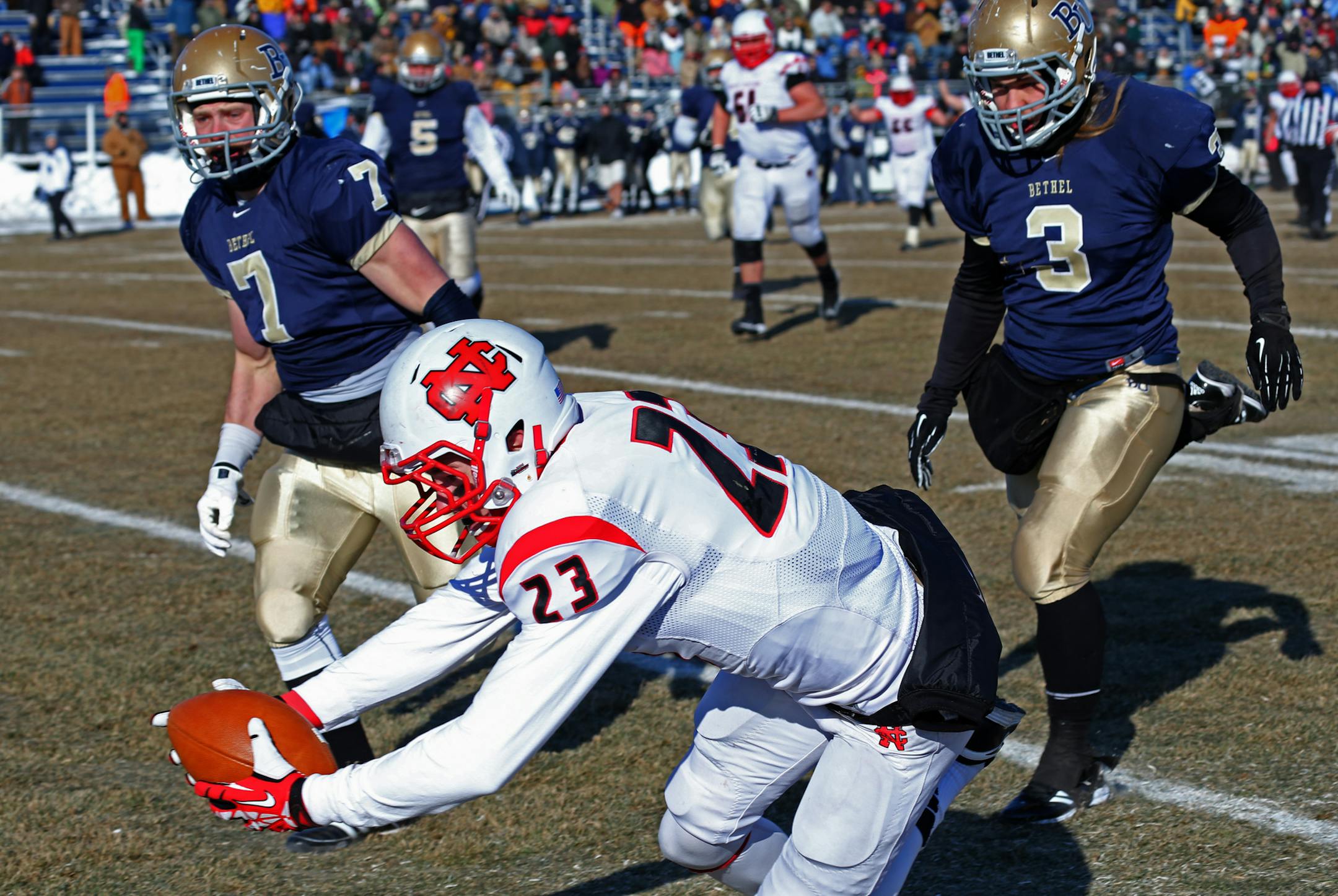 Bethel University vs. North Central, Division 3 NCAA playoff, Royal Stadium, 12/7/13. (center) North Central's Chad O'Kane dove into the endzone for a Cardinal touchdown as (right) Bethel's Josh Treimer and (left) Landon Mathis defended in first half action.] Bruce Bisping/Star Tribune bbisping@star Tribune.com Chad O'Kane, Josh Treimer, Landon Mathis/roster. ORG XMIT: MIN1312071734182229