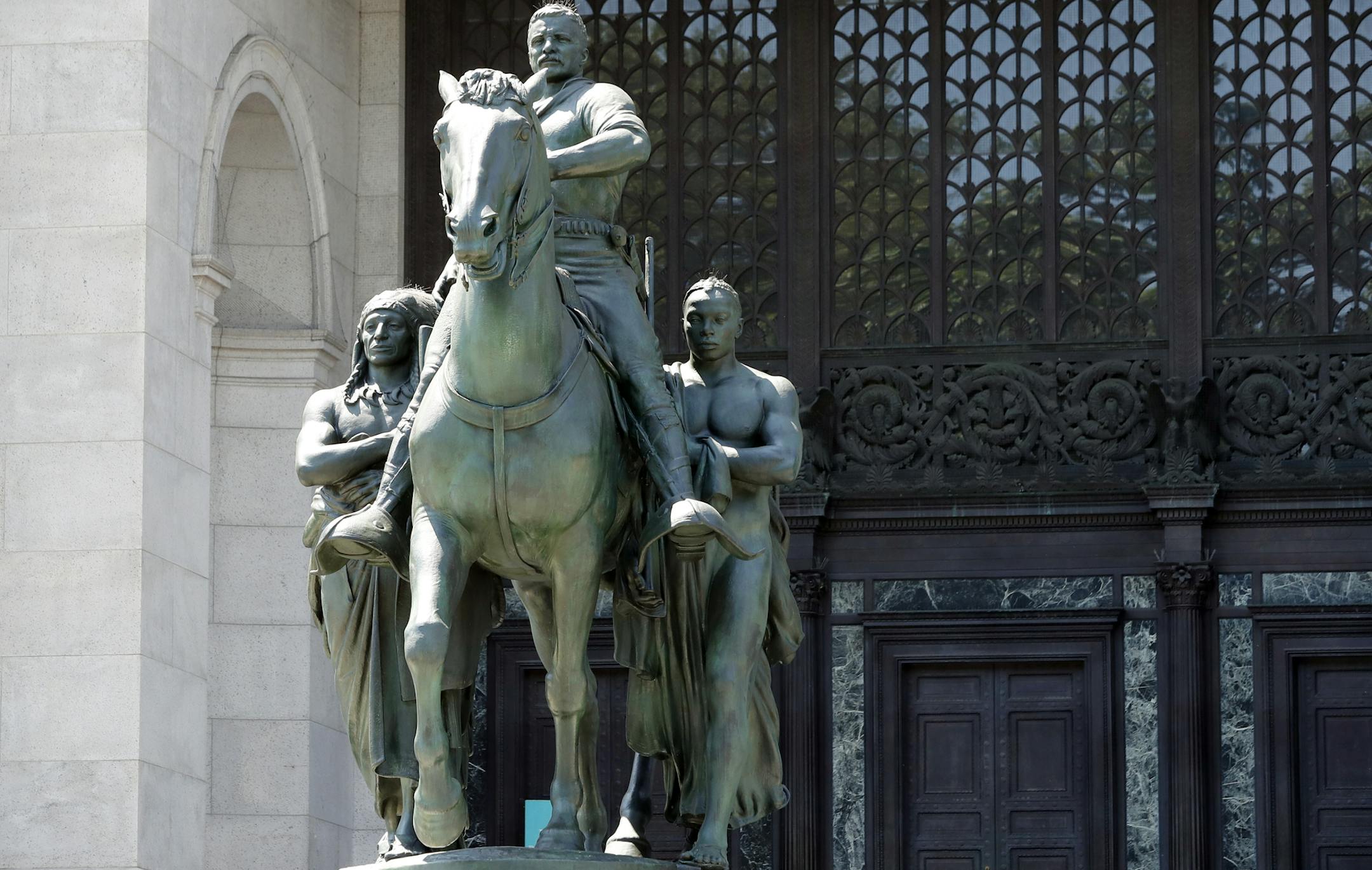 A statue of Theodore Roosevelt on horseback flanked by a Native American man, left, and an African man, right, sits in front of the American Museum of Natural History, Monday, June 22, 2020, in New York. The statue, which was installed in1940, will be taken down after objections that it symbolizes colonial expansion and racial discrimination. Mayor Bill de Blasio said Sunday the city supports removal of the statue because it depicts Black and Indigenous people as subjugated and racially inferior