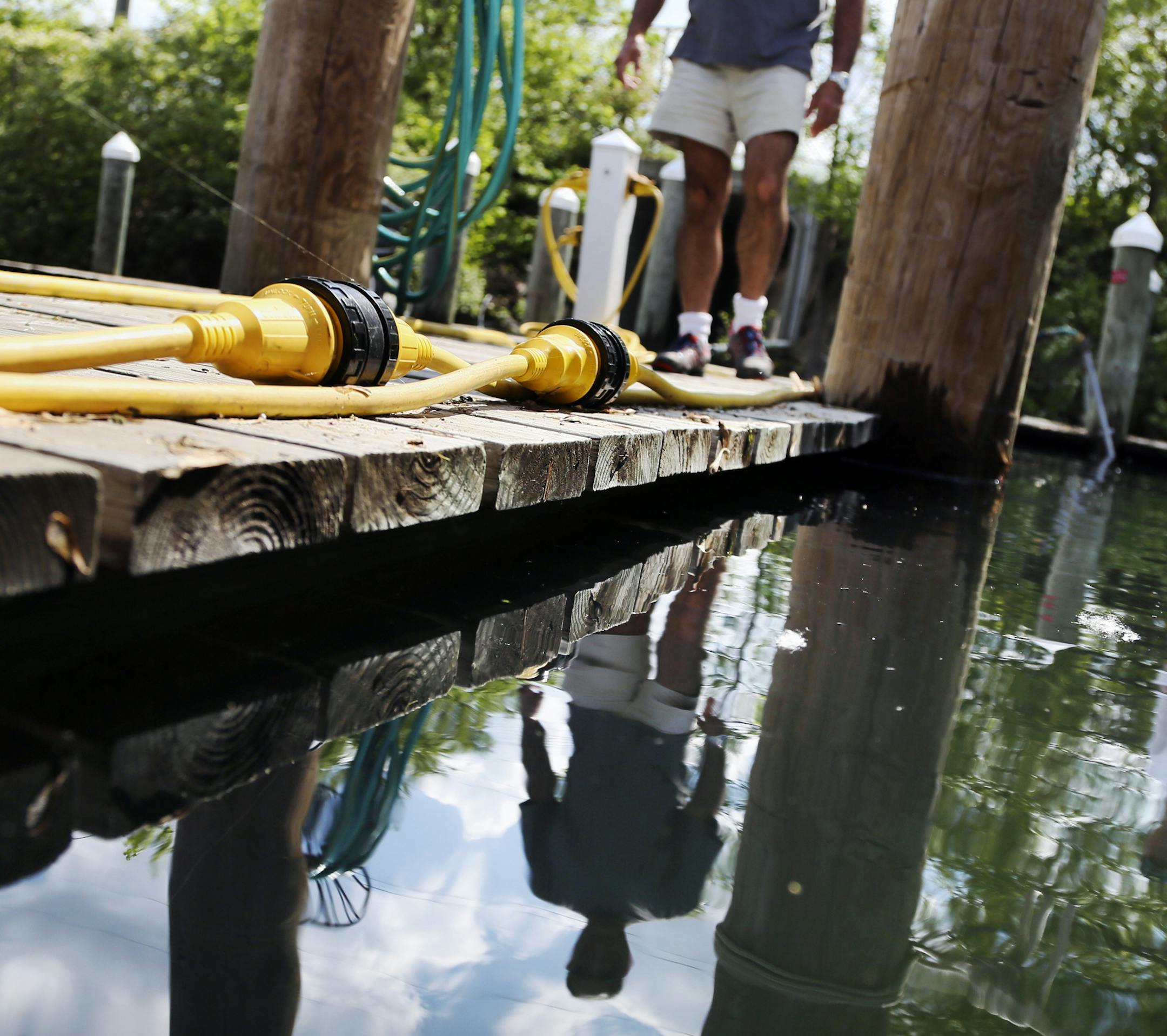 A rash of frequent, heavy rains has left Lake Minnetonka spilling over at a record height. At the Tonka Bay Marina in Excelsior Bay, marina owner Gabriel Jabbour, a former Orono mayor, walks along one of the docks on Wednesday, June 4, 2014.