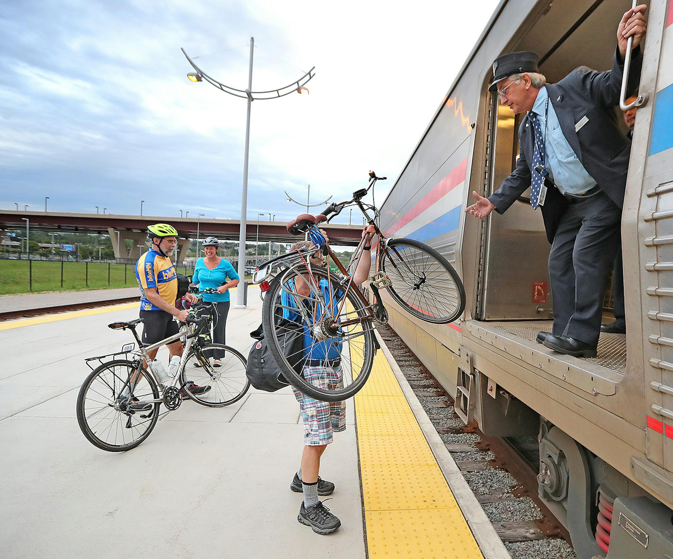 Amtrak Train Conductor Paul Trossen, cq, helped passengers lift their bikes onto the train, Monday, September 19, 2016 at the Union Depot in St. Paul, MN. Amtrak is expanding the ability of its passengers to bring their bikes along for the ride on its train network. ] (ELIZABETH FLORES/STAR TRIBUNE) ELIZABETH FLORES • eflores@startribune.com