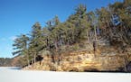 The sandstone cliffs at Mirror Lake State Park provide a stunning contrast with the white snow on the frozen lake.