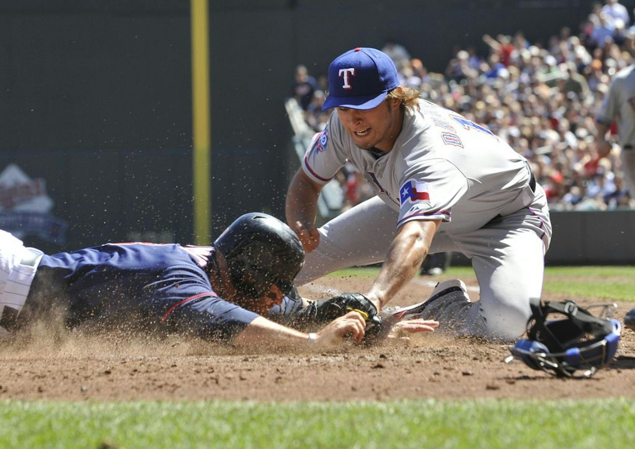 Texas pitcher Yu Darvish, covering the plate, tags out Minnesota's Ryan Doumit as he attempted to score on a runner's fielders choice in the fourth inning Saturday.