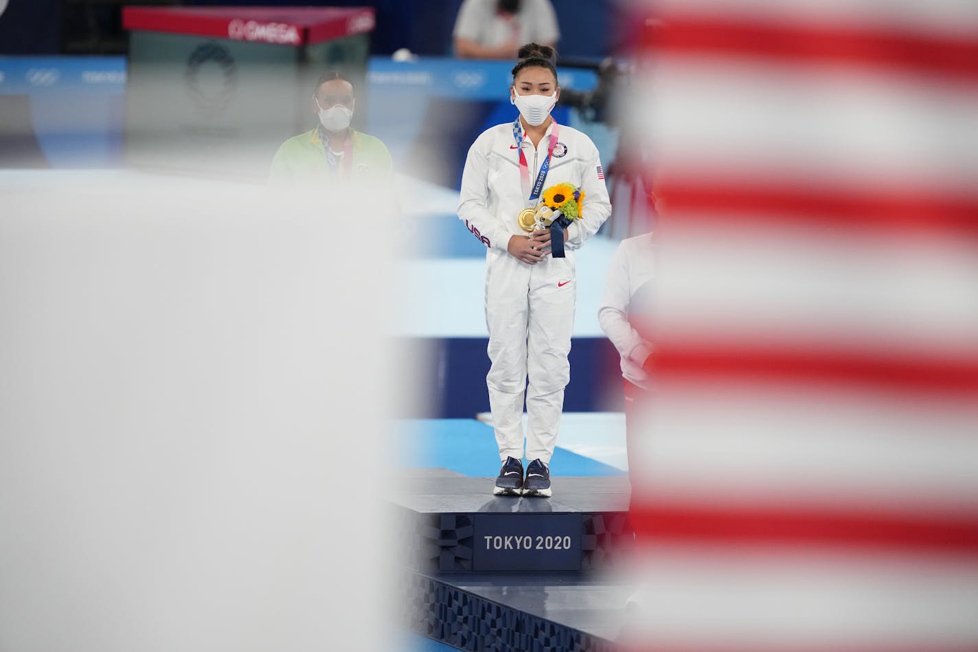 Sunisa Lee of the United States, center, with her gold medal and Rebeca Andrade of Brazil, left, with her silver medal, stand during the medal ceremony following the women's all-around gymnastics competition at the postponed 2020 Tokyo Olympics in Tokyo on Thursday, July 29, 2021. (Chang W. Lee/The New York Times)