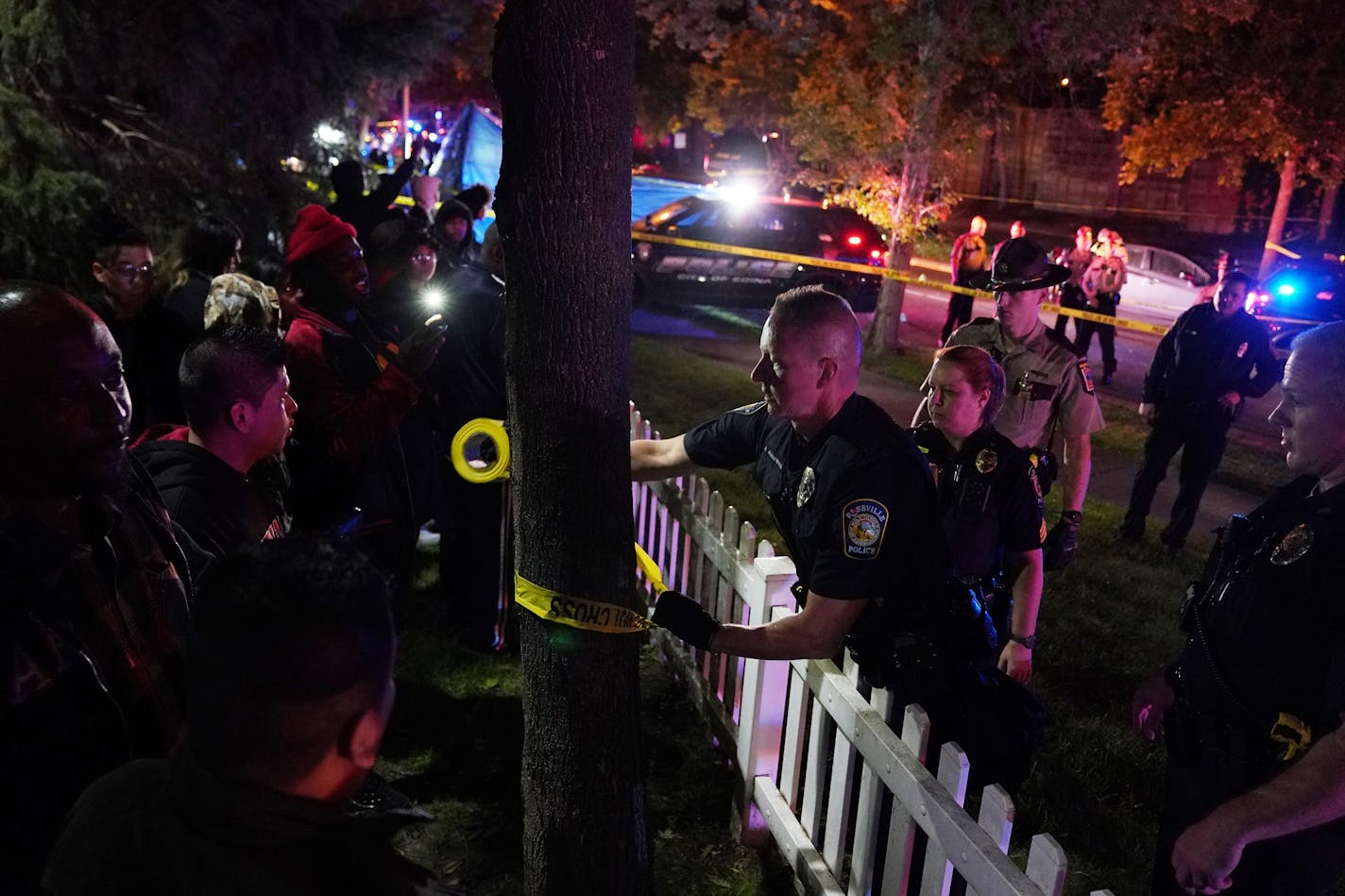 Police used tape to expand the crime scene as they tried to block the view of a body at the scene of an officer involved shooting on East 77th Street in Richfield.