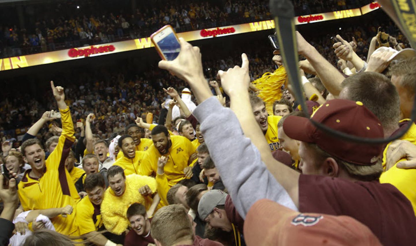 Gopher fans and players celebrated their 77-73 win over Indiana by rushing the floor at Williams Arena.