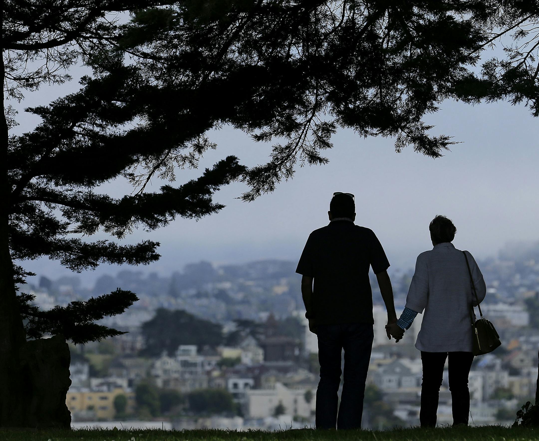 FILE- In this July 3, 2017, file photo a man and woman walk under trees down a path at Alta Plaza Park in San Francisco. Looking at the income, living expenses and life spans of today’s retirees can help you make the right financial moves so your golden years aren’t tarnished by an unexpected shortfall. (AP Photo/Jeff Chiu, File)