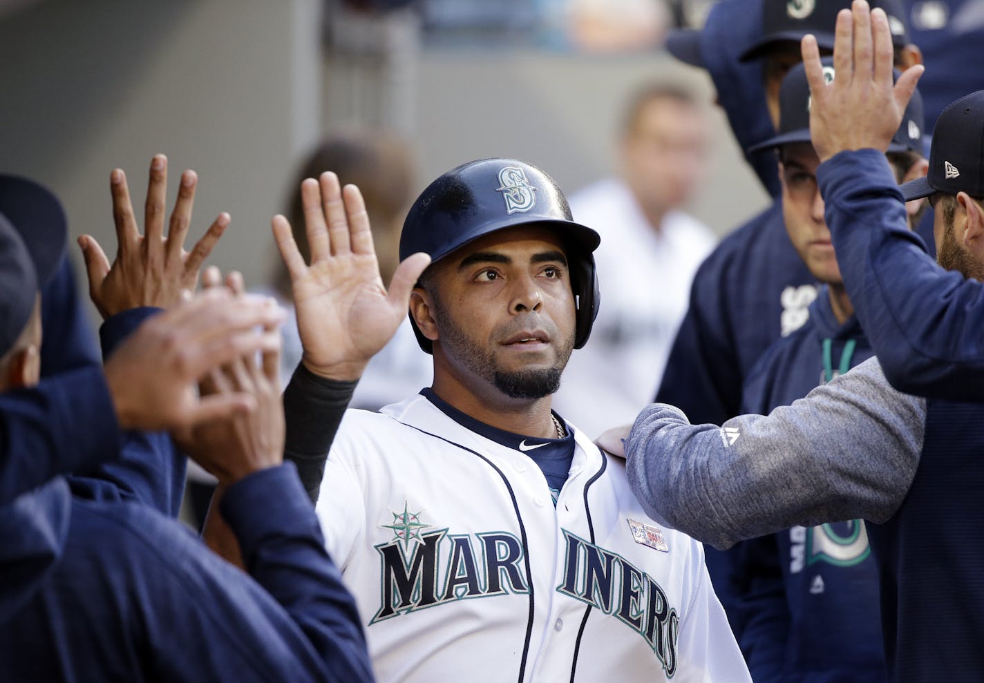 Seattle Mariners' Nelson Cruz is congratulated after scoring against the Tampa Bay Rays in the second inning of a baseball game Saturday, June 3, 2017, in Seattle. (AP Photo/Elaine Thompson)