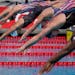 Katie Ledecky, center, and other swimmers jump in the pool at the start of the women's 100-meter freestyle final at the TYR Pro Swim Series swim meet 