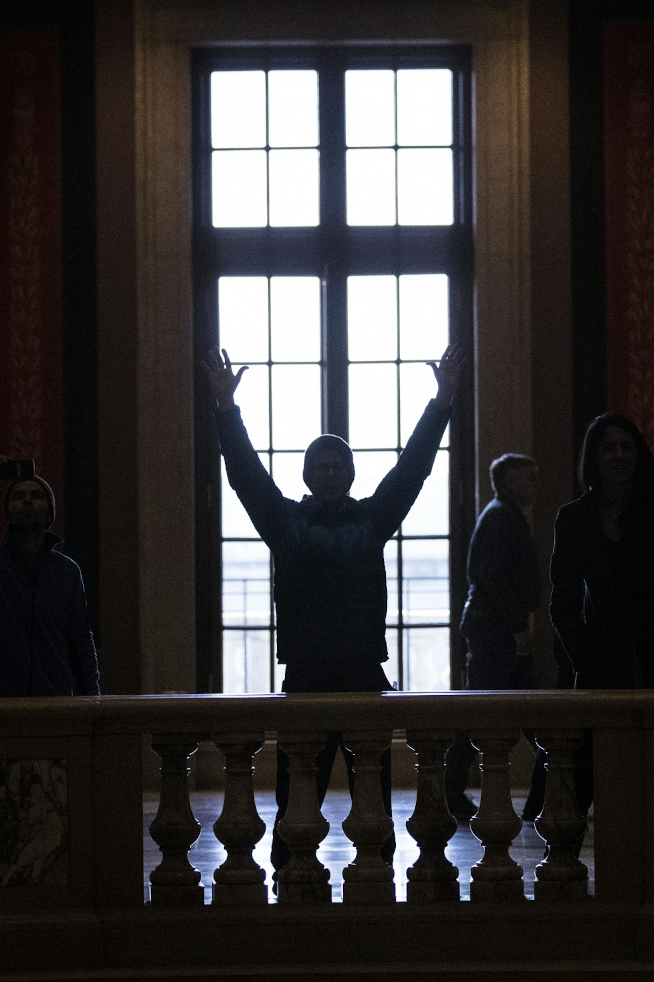 A man raises his hand in prayer during the singing of "God Bless America" during a prayer service in the rotunda area of the Capitol.