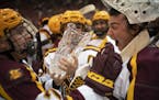 Minnesota Gophers forward Brannon McManus, left, handed the trophy to goalie Jack LaFontaine after the Gophers' Mariucci Classic win.
