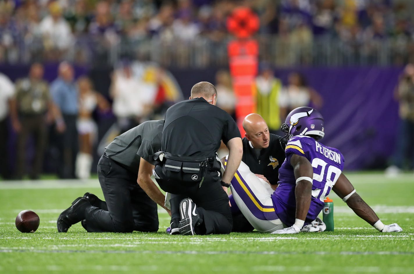 Adrian Peterson is tended to by the training staff after his knee injury in the third quarter of Sunday's game.