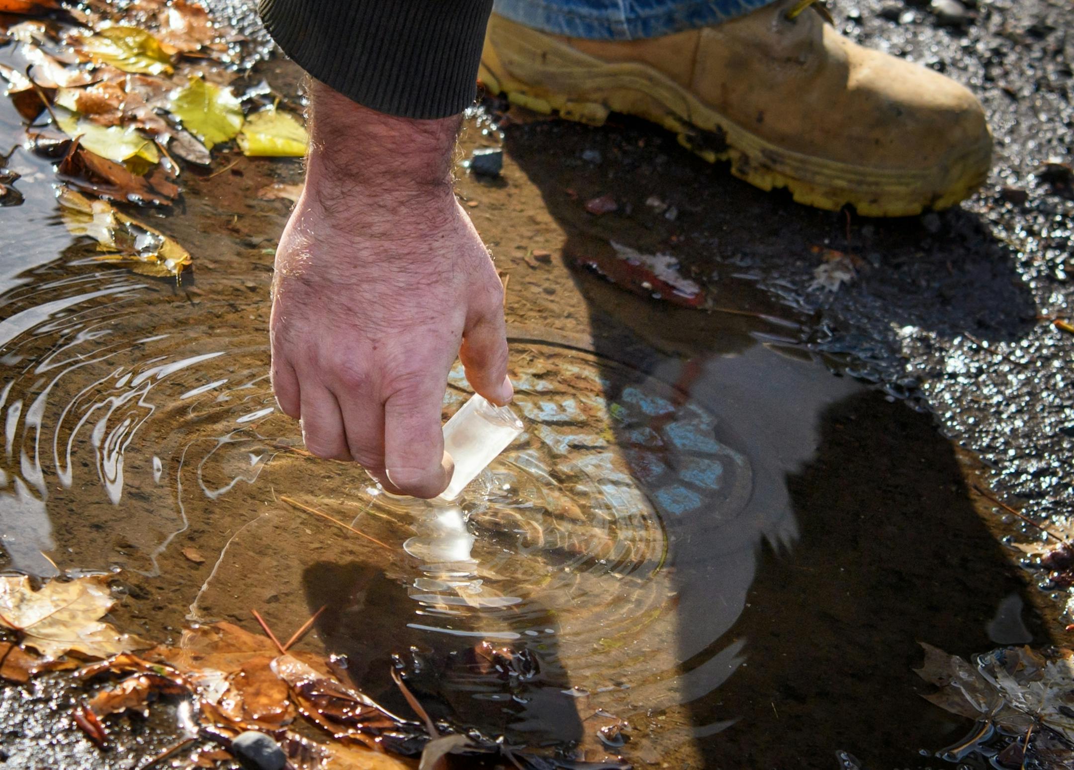 Josh Carlson takes a water sample to detect chlorine to determine if this standing water is naturally occurring or leaking from the public water supply. Josh Carlson and David Wuebkers are "leak seekers" part of Duluth's public works department who track leaks in the system.