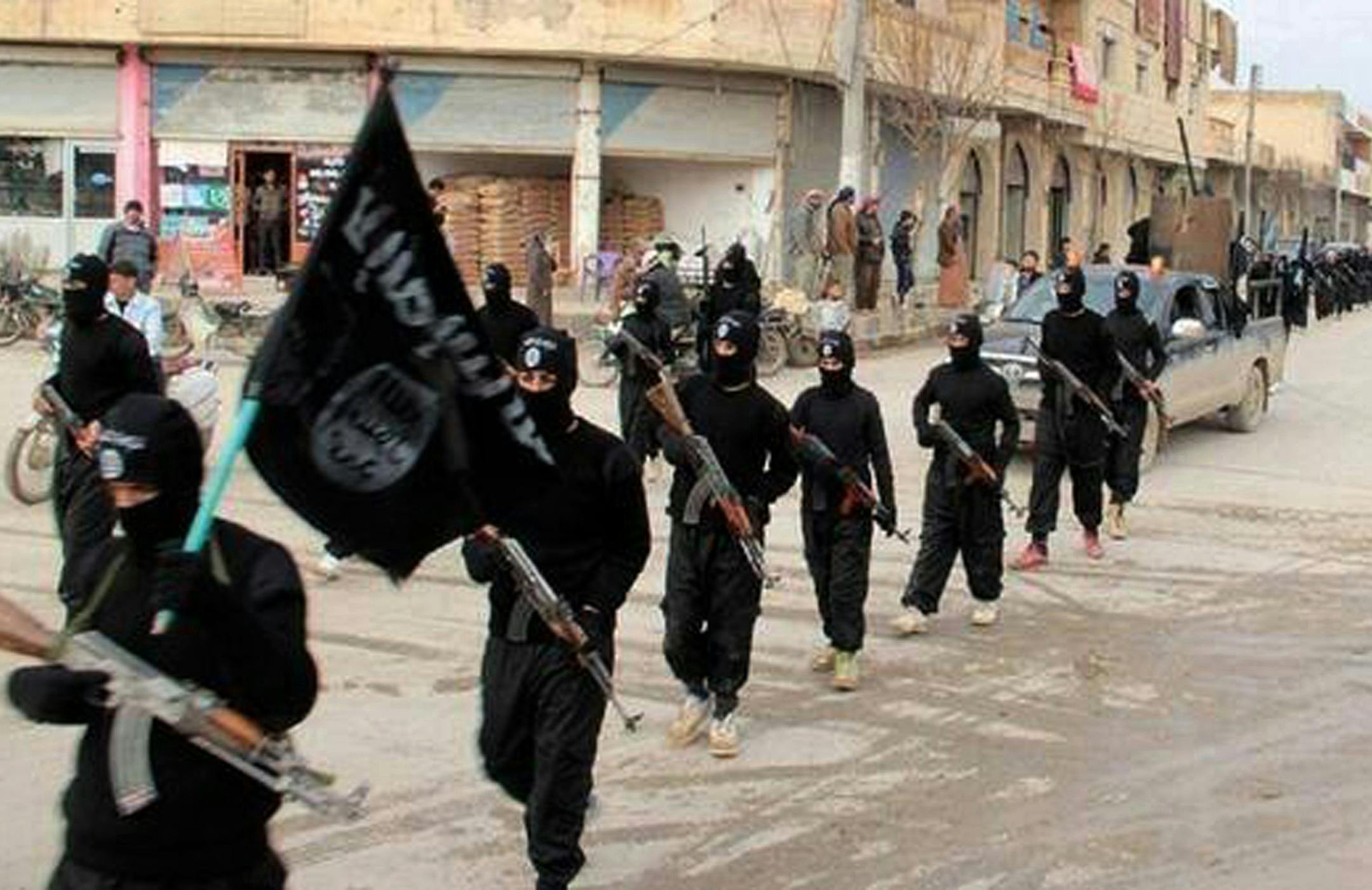 FILE - This undated file image posted on a militant website on Tuesday, Jan. 14, 2014, which has been verified and is consistent with other AP reporting, shows fighters from the al-Qaida linked Islamic State of Iraq and the Levant (ISIL) marching in Raqqa, Syria. Across the broad swath of territory it controls from northern Syria through northern and western Iraq, the extremist group known as the Islamic State has proven to be highly organized governors. (AP Photo/Militant Website, File) ORG XMI