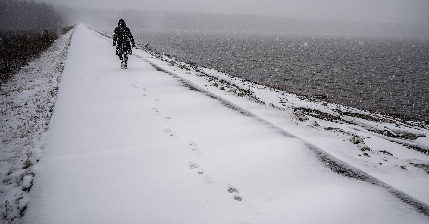 A woman walked along the shoreline of lock and dam # 2 in Hasting near the site where a proposed 40-acre island will be constructed to block the wind and protect the shoreline from erosion.