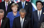 President Barack Obama, center, flanked by Turkish President Recep Tayyip Erdogan, left, looks down as German Chancellor Angela Merkel and Japanese Pr