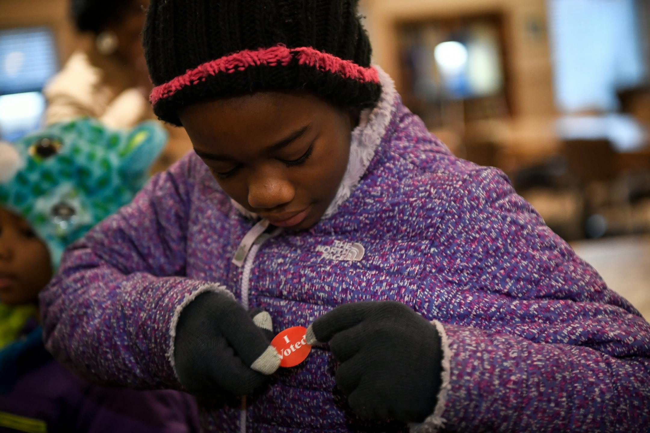 Maylena Carter, 11, the daughter of St. Paul mayoral candidate Melvin Carter, placed a "I Voted" sticker on her coat after her parents voted early Tuesday morning at Ravoux Hi-Rise in St. Paul.