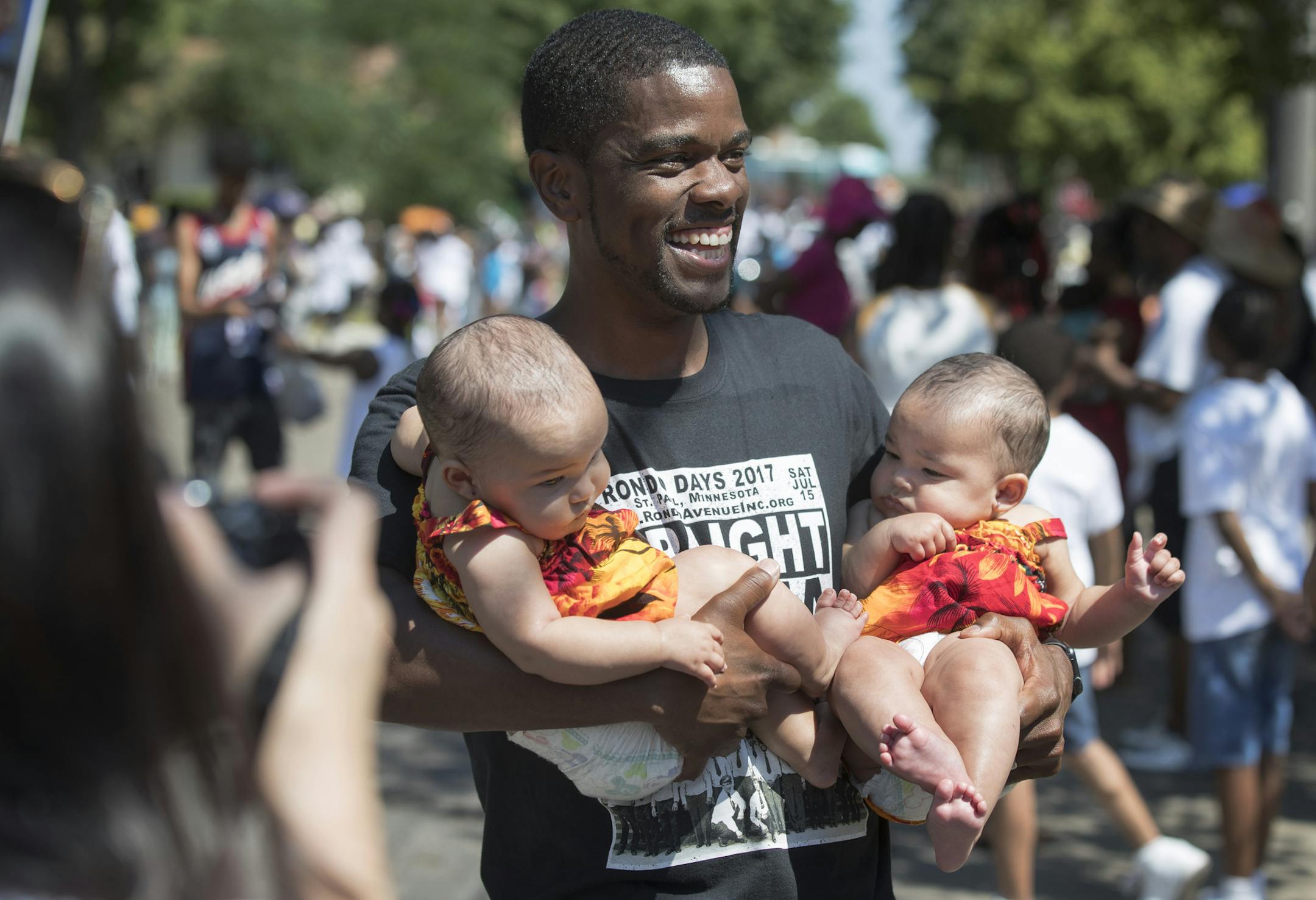 St. Paul mayoral candidate Melvin Carter held 6 -month -old twin sister Zonea Vreeland left and Zaria Vreeland while campaigning with supporters in the annual Rondo Days parade Saturday July 15 2017 in St. Paul, MN. ] JERRY HOLT ï jerry.holt@startribune.com ORG XMIT: MIN1707171529142734