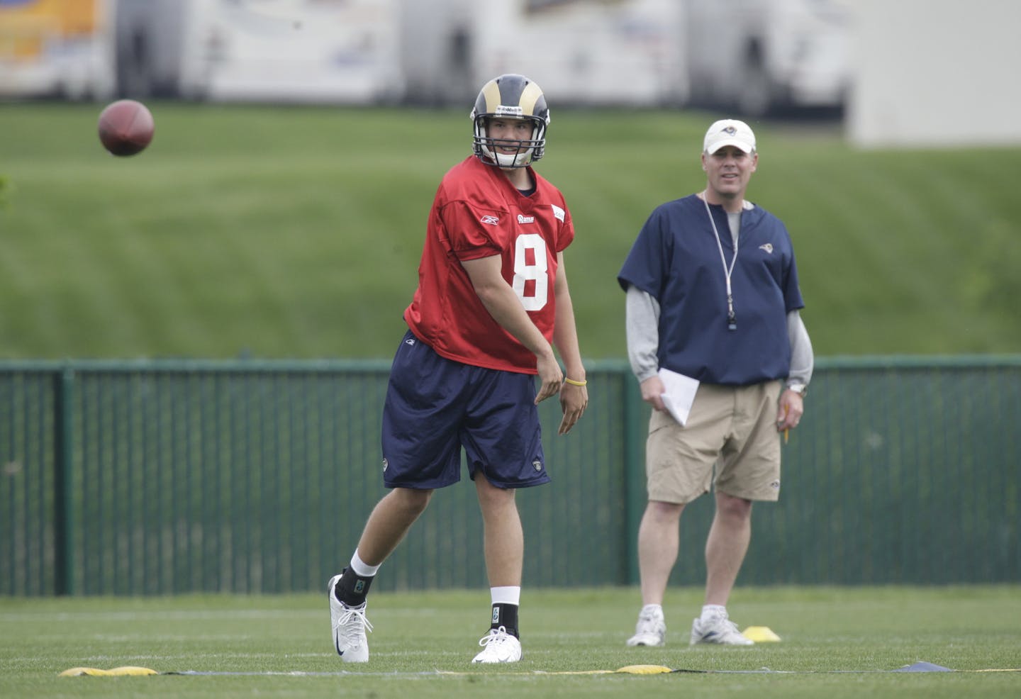 St. Louis Rams quarterback Sam Bradford throws as offensive coordinator Pat Shurmur looks on during rookie football mini-camp Friday, April 30, 2010, in St. Louis. (AP Photo/Jeff Roberson) ORG XMIT: NYOTK