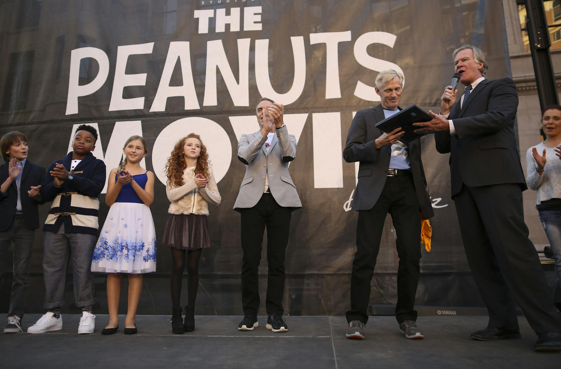 St. Paul Mayor Chris Coleman handed the proclamation to Craig Schulz after reading it to the assembled crowd. Others sharing the stage were the kids who voice some of the characters in THE PEANUTS MOVIE. The kids are, from left, Noah Schnapp, who is the voice of Charlie Brown; Mar Mar, who is the voice of Franklin; Hadley Belle Miller, who is the voice of Lucy; and Francesca Capaldi, who is the voice of the Little Red Haired Girl. Next to Capaldi is director Steve Martino. ] JEFF WHEELER ï