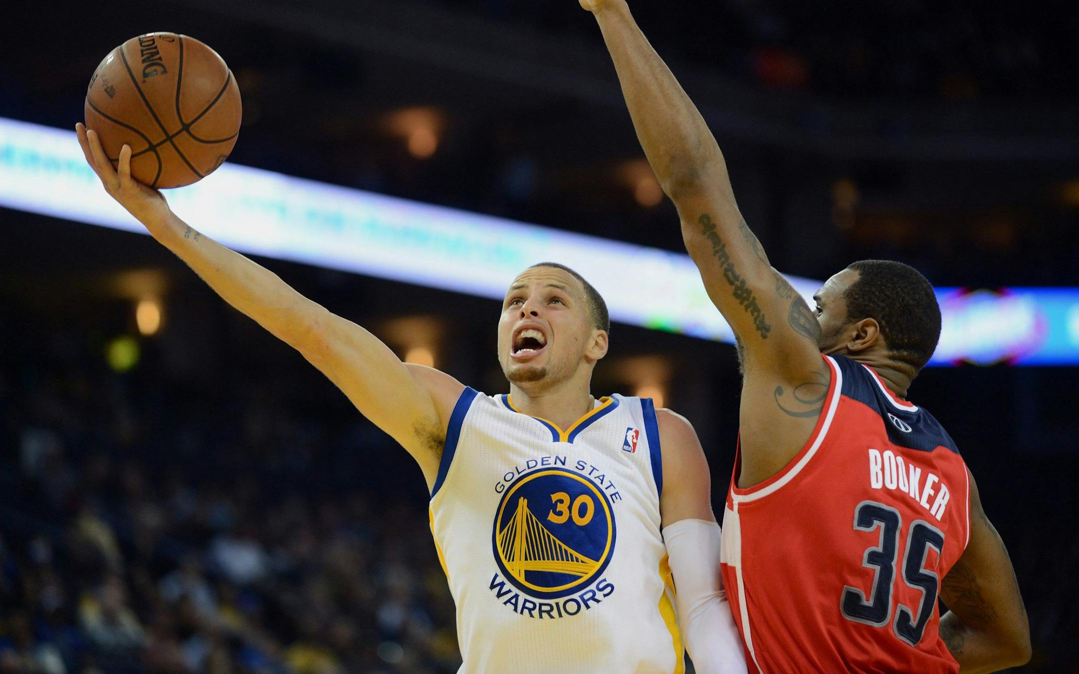 The Golden State Warriors' Stephen Curry (30) drives for a score against the Washington Wizards' Trevor Booker (35) in the second half at the Oracle Arena in Oakland, Calif., on Tuesday, Jan. 28, 2014. (Dan Honda/Bay Area News Group/MCT) ORG XMIT: 1148464 ORG XMIT: MIN1401282351443968