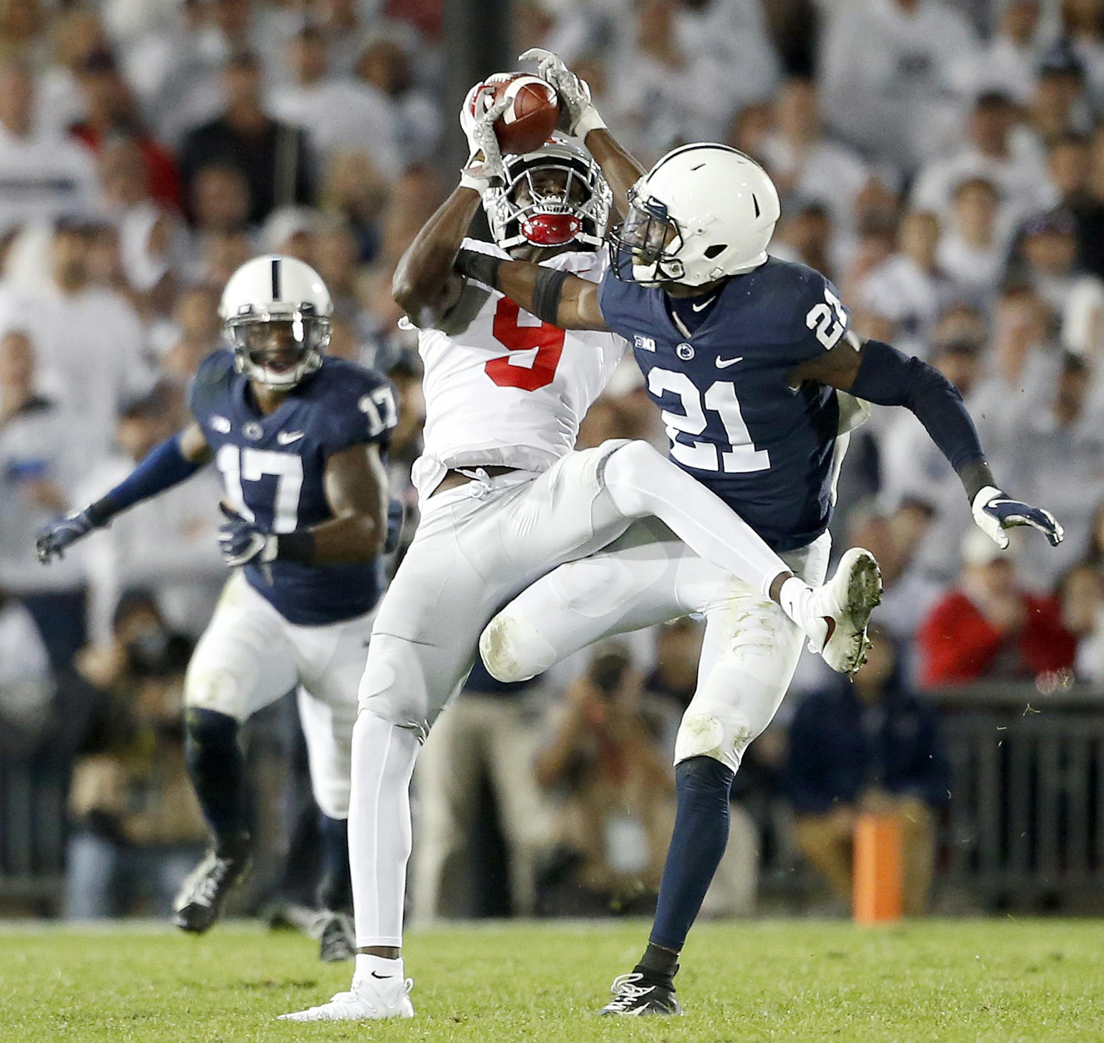 Ohio State's Binjimen Victor (9) catches a pass in front of Penn State's Amani Oruwariye (21) and runs in for a touchdown during the second half of an NCAA college football game in State College, Pa., Saturday, Sept. 29, 2018. Ohio State won 27-26. (AP Photo/Chris Knight)