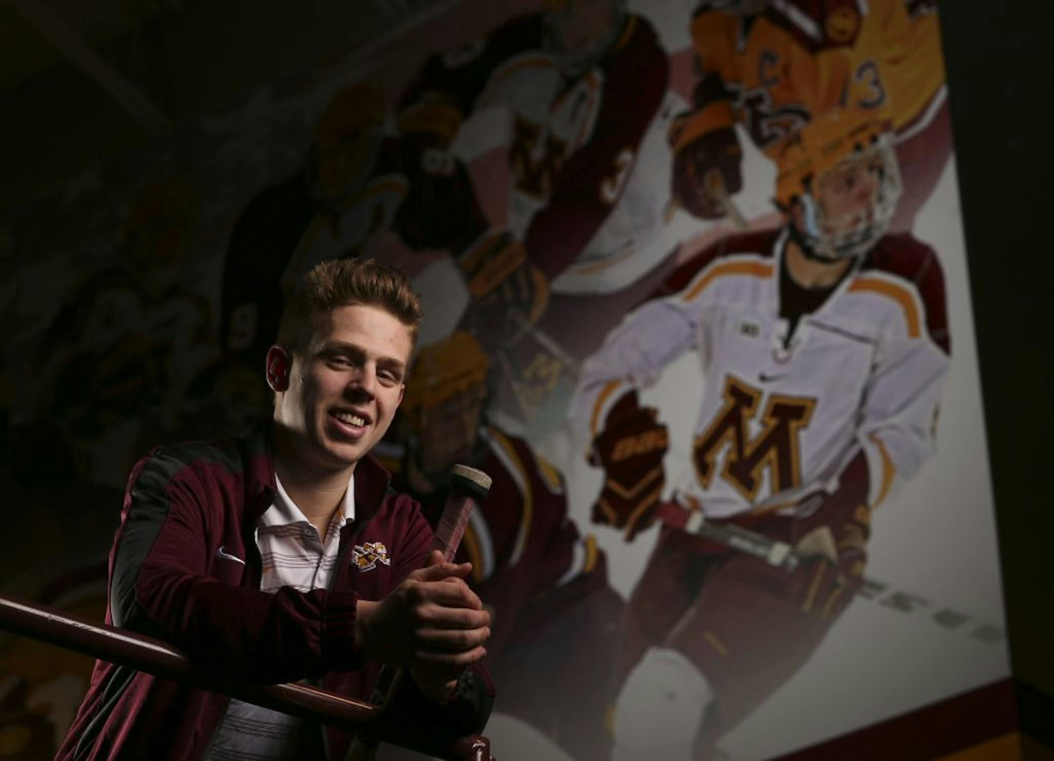Gophers' junior defenseman Mike Reilly with the mural at Mariucci Arena where his image was added to the previous hockey All-America selections.