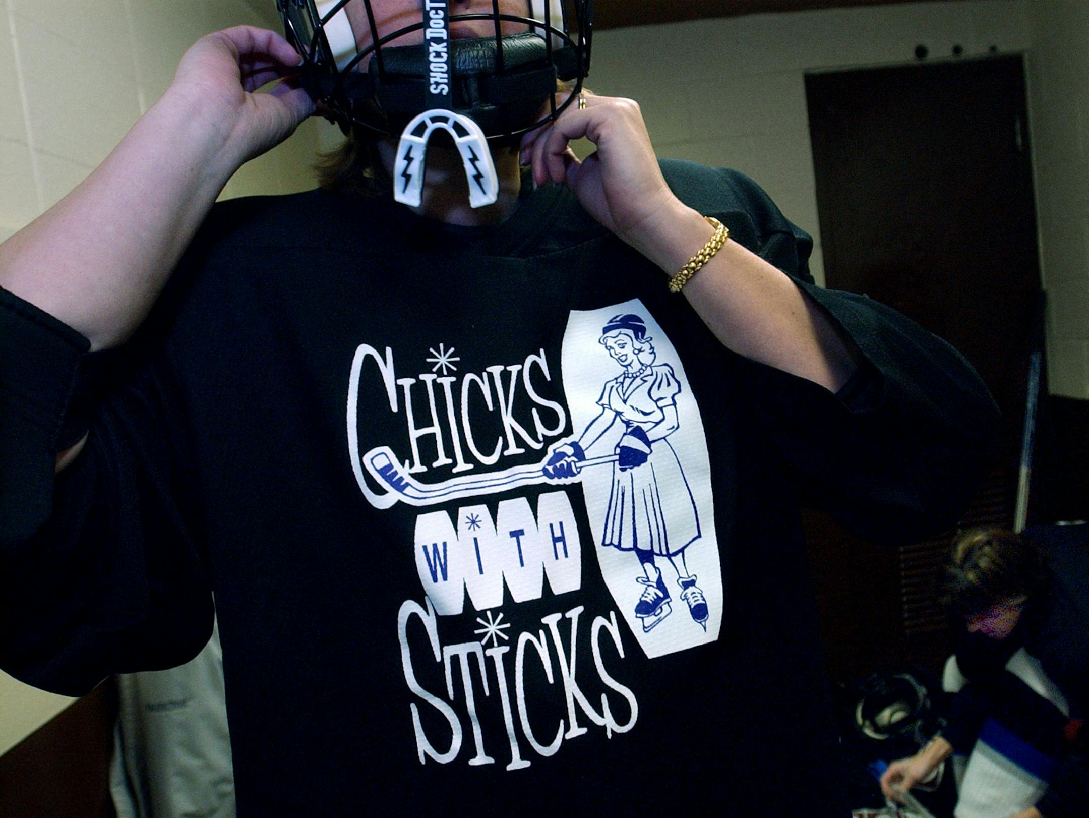 Mound, Mn., Weds., Dec. 17, 2003--Sarah Sjoquist shows her "Chicks with Sticks" jersey that coach Mike Curti designed for his clinic for moms who want to learn the game of hockey. The clinic is held at Herald T. Pond Arena in Mound.
GENERAL INFORMATION: A hockey clinic for moms who want to learn the game is being offered at Herald T. Pond Arena in Mound.
