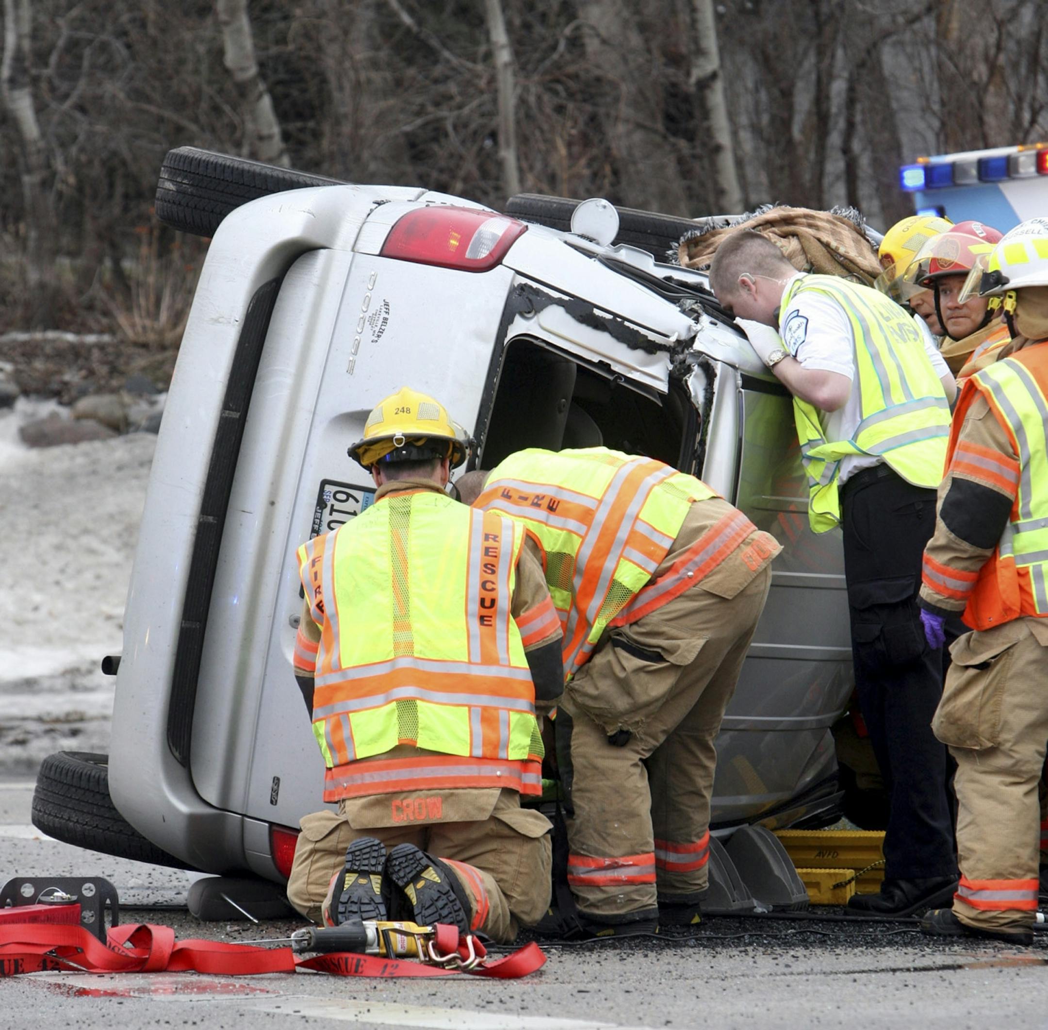 An Allina EMS paramedic peers into a van to check on five people who were trapped in the minivan after a multiple vehicle crash at McAndrews and Gardenview in Apple Valley around 3 p.m. on Saturday, April 6. One victim was flown from the scene and five others were transported by ambulance. Photo by Peter Matthews