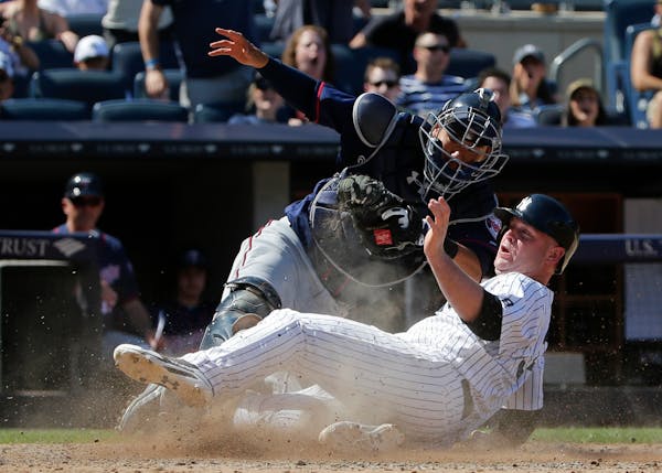 New York Yankees' Brian McCann, right, is tagged out at home plate by Minnesota Twins catcher Kurt Suzuki during the eighth inning of a baseball game 