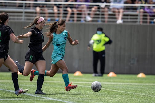 Minnesota Aurora' Mariah Nguyen pushed the ball up the field past Lions' Kelsey Kehoe, en route to scoring in the first half.
