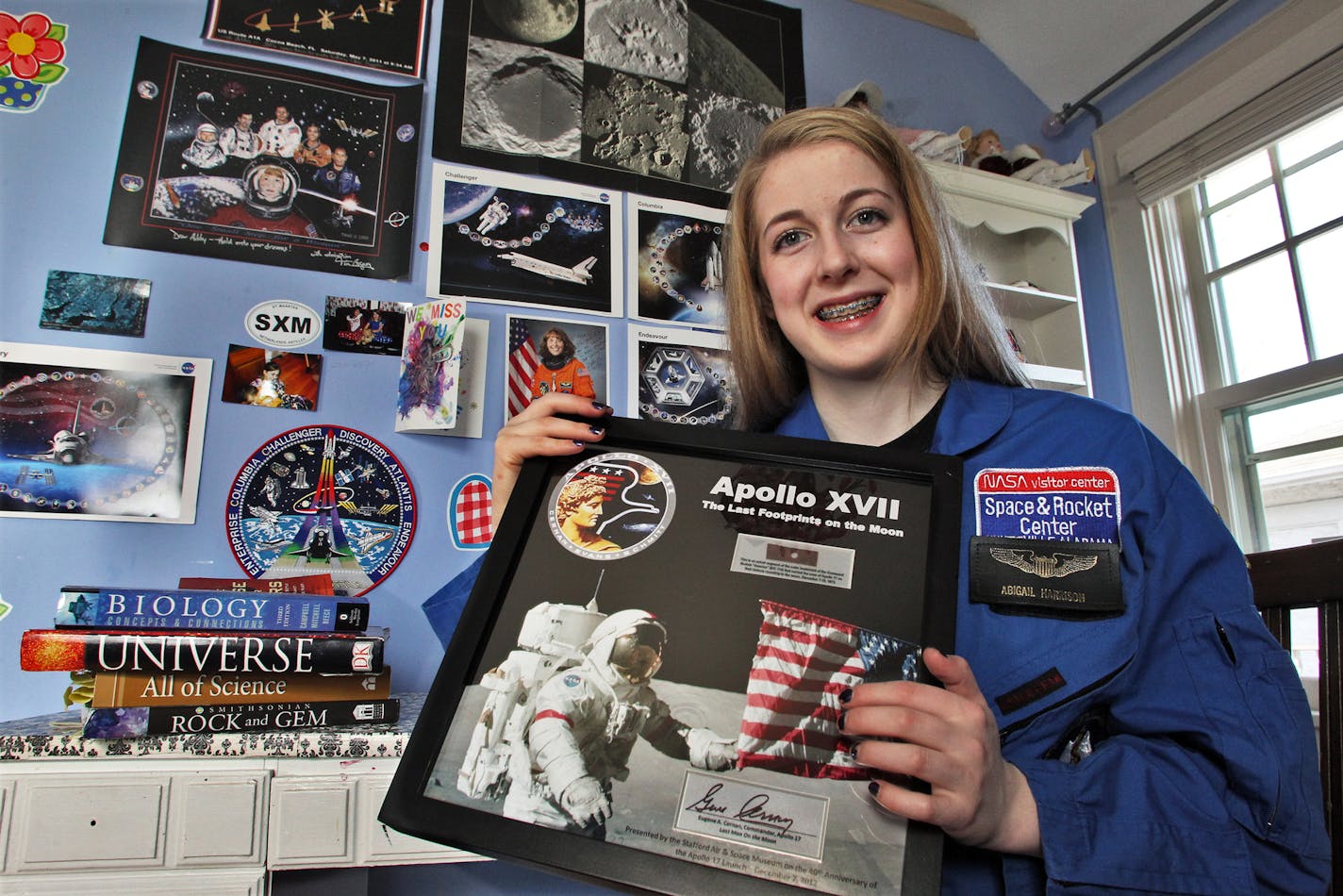 Minneapolis teenager Abby Harrison is obsessed with becoming an astronaut and will soon be traveling to Russia for the next manned launch to the space station. Photographed here in her bedroom with space flight paraphenalia on her walls. She held a keepsake she was given for attending a recent Apollo 17 commemorative dinner. (MARLIN LEVISON/STARTRIBUNE(mlevison@startribune.com (cq ) ORG XMIT: MIN1305130049111487