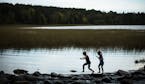 Lidia Ravaska, 8, left, and her sister Gabriella, 7, of Dassel Cokato, played on the rocks at the Mississippi Headwaters in Itasca State Park on Sunda
