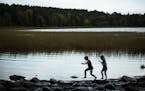 Lidia Ravaska, 8, left, and her sister Gabriella, 7, of Dassel Cokato, played on the rocks at the Mississippi Headwaters in Itasca State Park on Sunda
