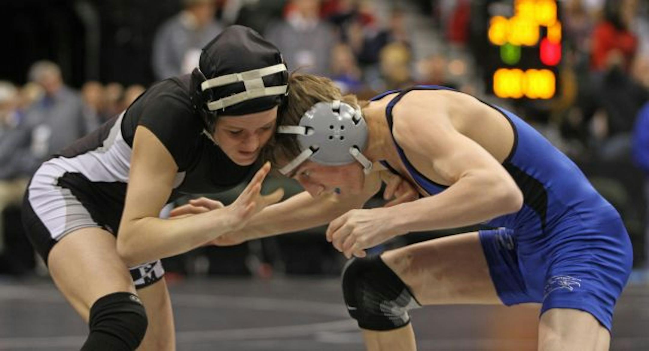 (left to right) Fluda/Murray County Central's Elissa Reinsma and Foley's Tristan Manderfeld battled during a Class A 103 pound match at the State Wrestling Tournament. Manderfield won the match.