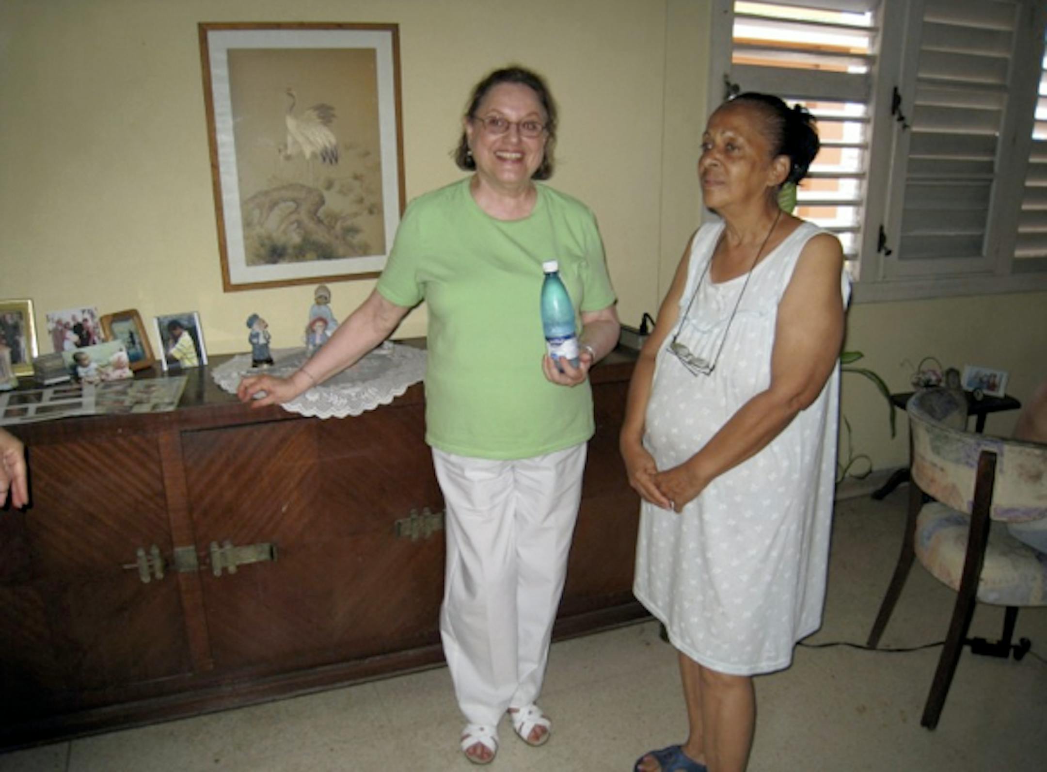 Dalia Katz posed next to a cabinet she left in her Havana apartment when she came to the U.S. almost 50 years ago. She knocked on the apartment door during a recent visit and met the woman in this photo (and her family) living among her former possessions.