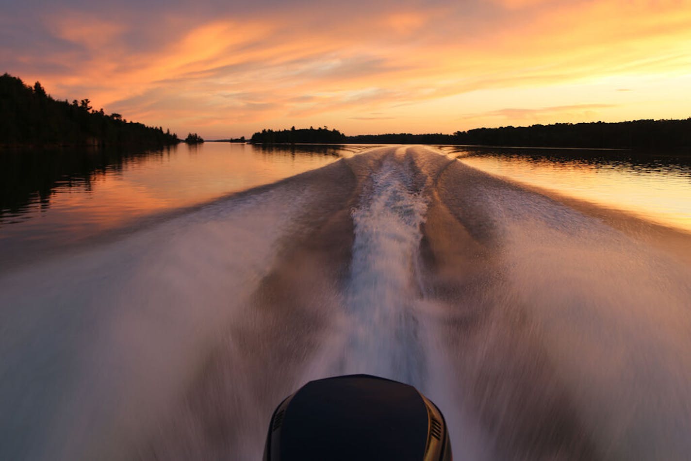 After a long day's fishing on Lake of the Woods near Big Narrows, which lies about halfway between Minnesota's Northwest Angle and Kenora, Ontario, the big lake lay flat at sunset, its surface yielding a neat wake behind a boat headed for camp.