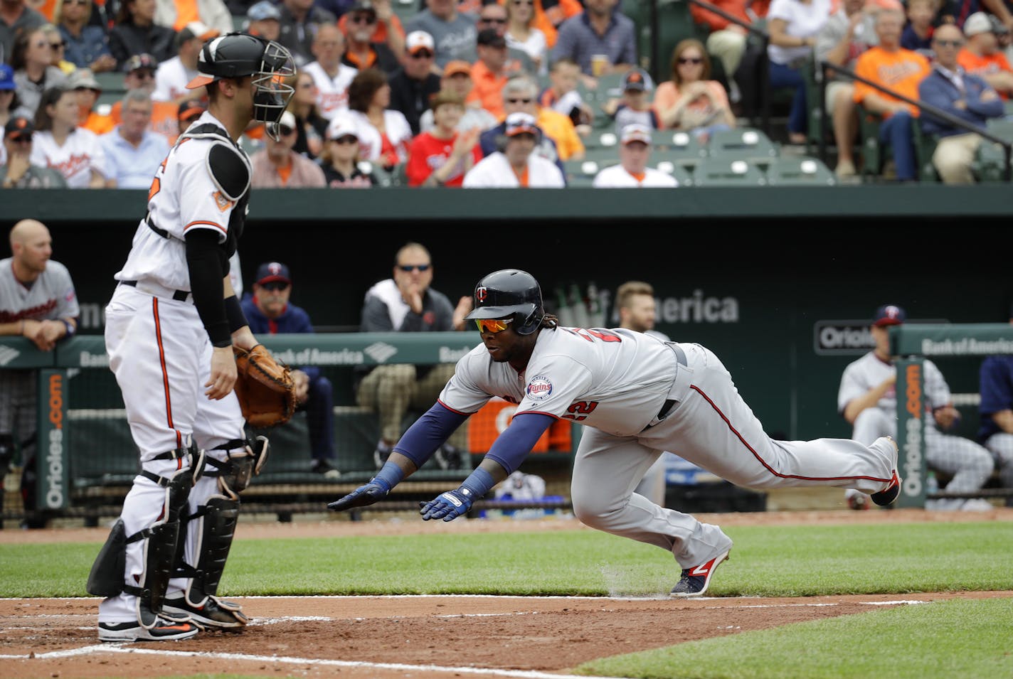 Minnesota Twins' Miguel Sano, right, dives past Baltimore Orioles catcher Caleb Joseph.