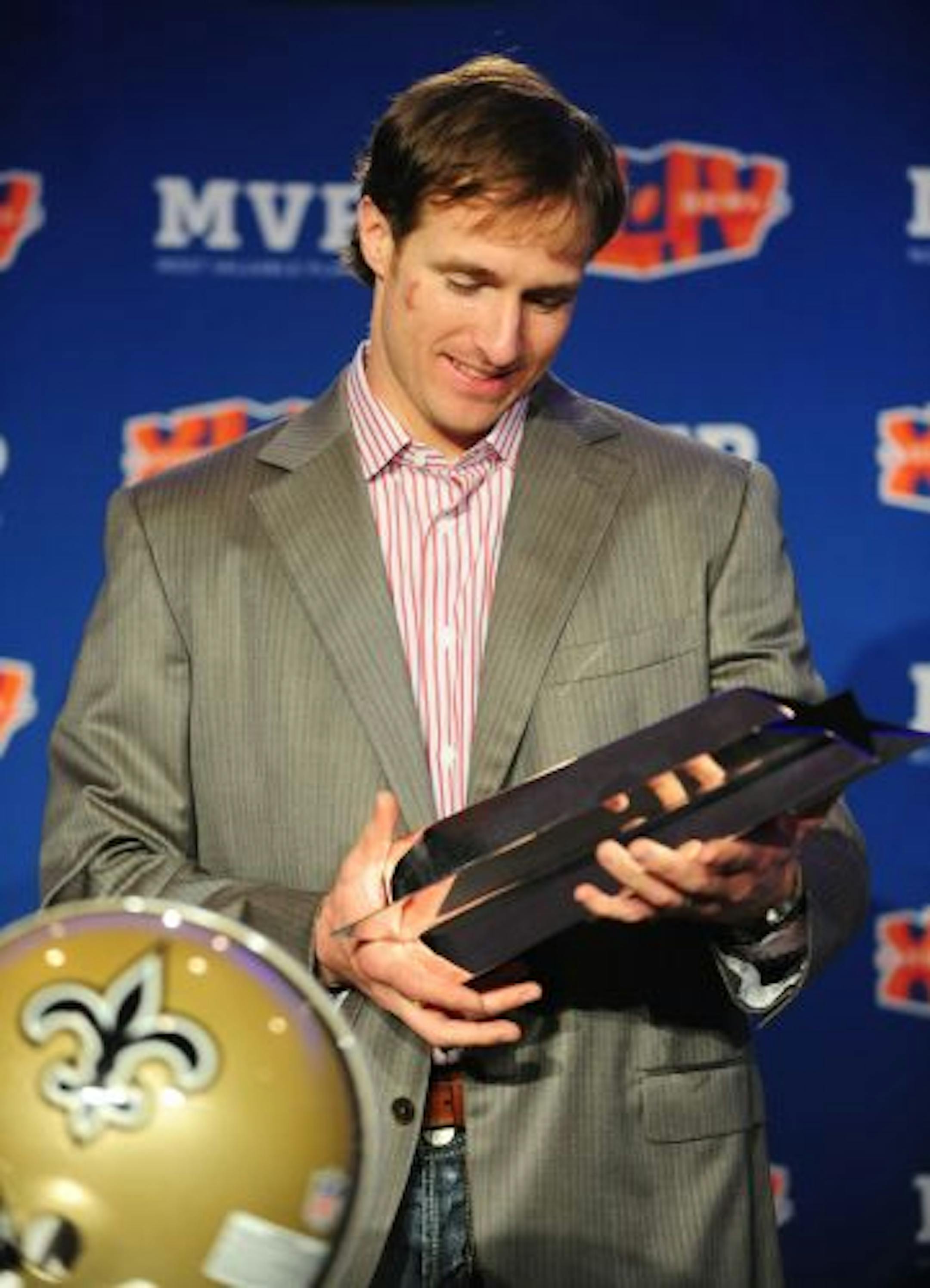 New Orleans Saints quarterback Drew Brees looks over the MVP trophy.